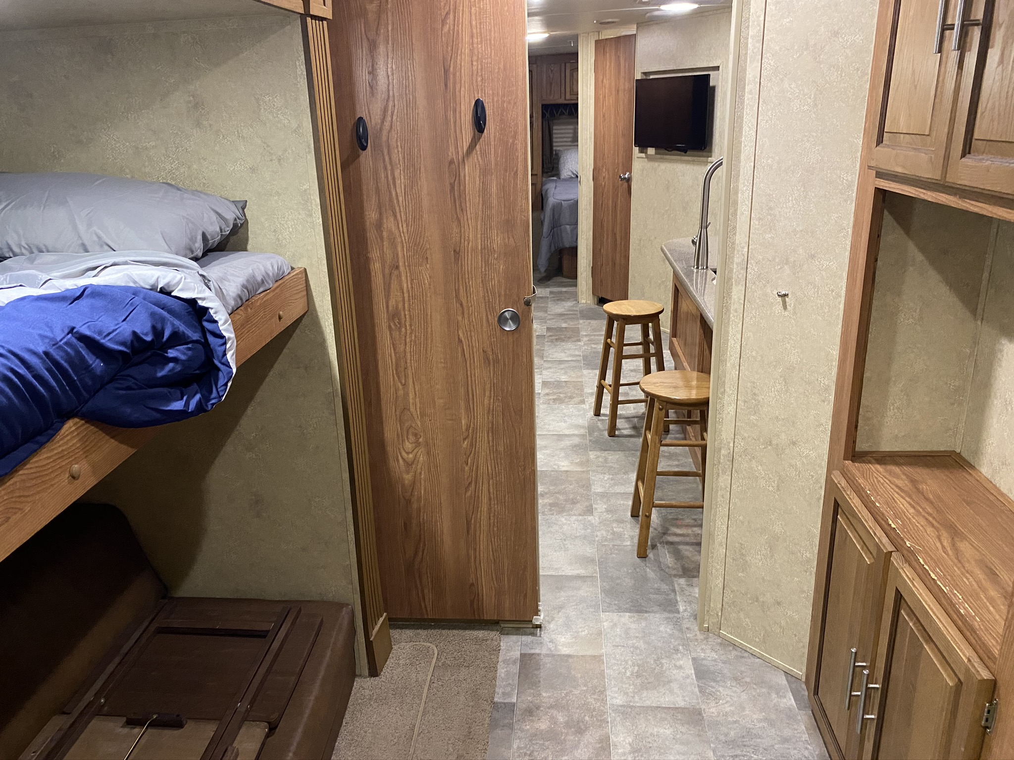 RV rental interior: cozy bunk beds, kitchen area with bar stools, and a functional living space.. Forest River Flagstaff Classic Super Lite 2015
