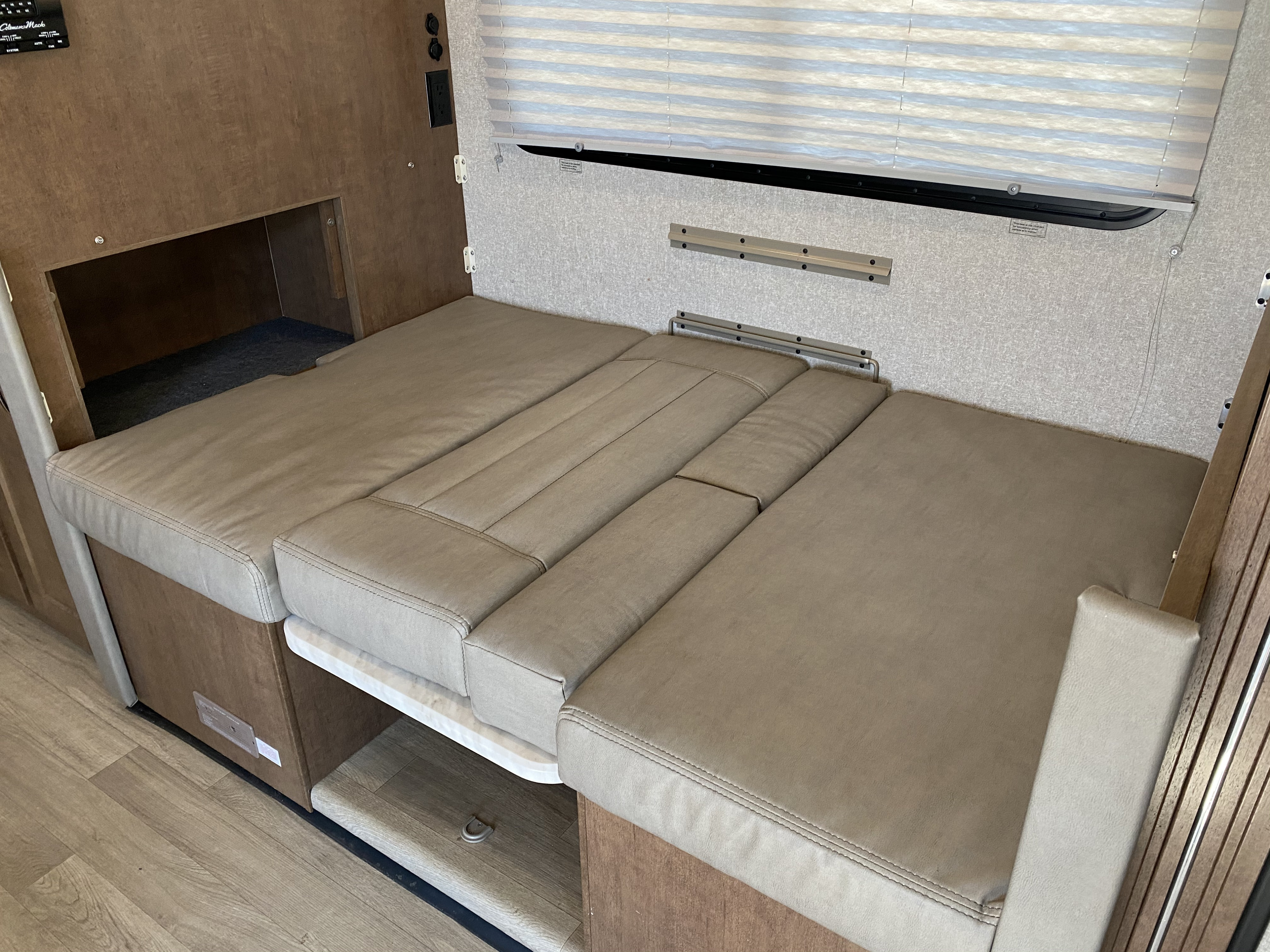 Cozy RV rental interior: tan convertible dinette bed/seating with comfy cushions.. Winnebago Vita 2020