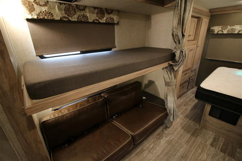 RV rental bunk bed setup. Features a top bunk, lower convertible sofa, and storage cabinets in the cozy interior.. Forest River Forester 2020