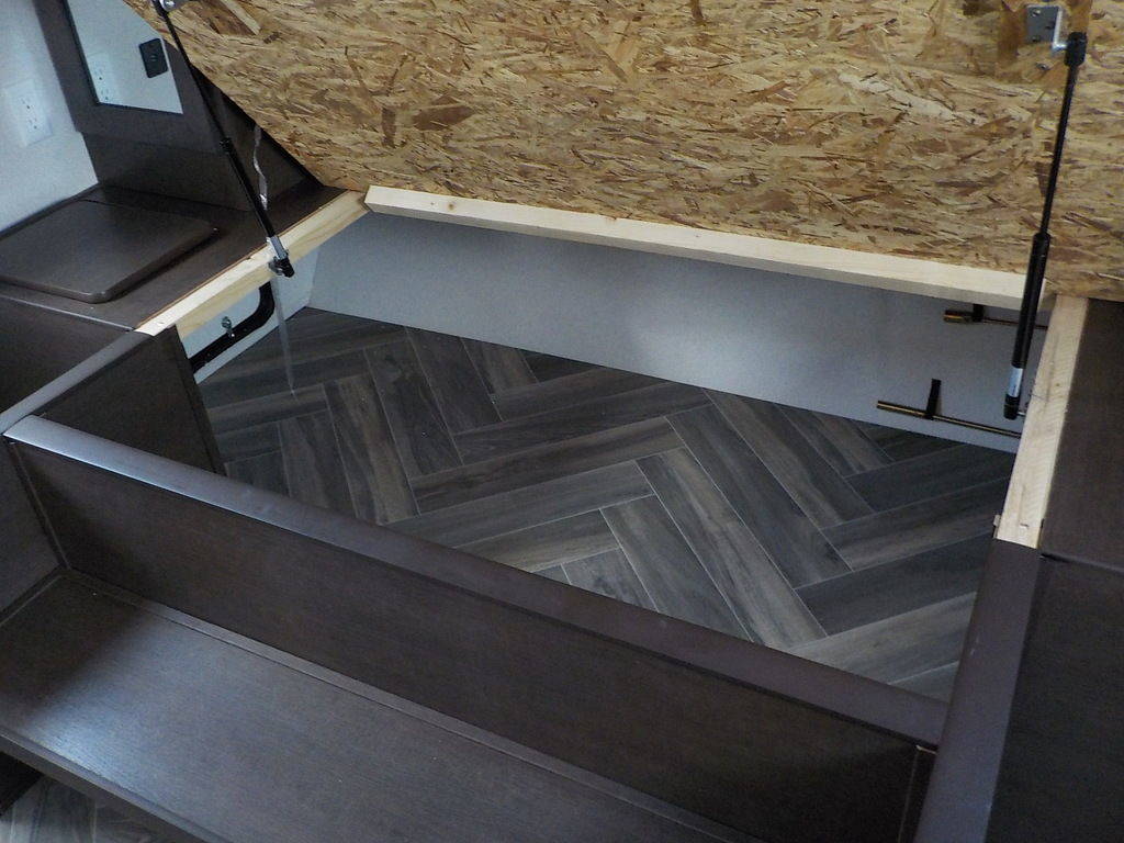 RV rental: Lifted under-bed storage compartment with herringbone floor. Gas struts secure the OSB lid. Ideal for gear.. Forest River Evo 2021