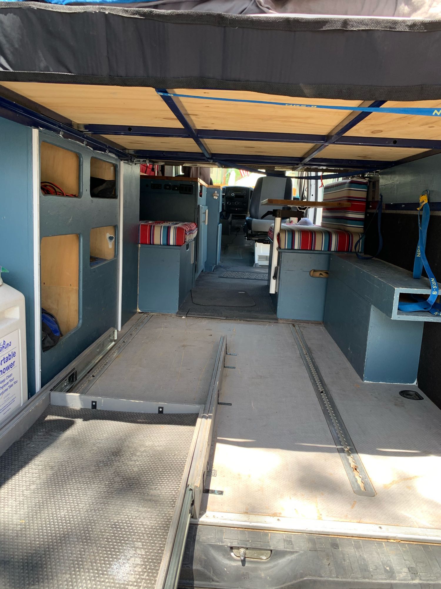 Custom camper van interior with a unique pull-out bed, perfect for your next RV rental adventure.. Dodge Sprinter Van 2008