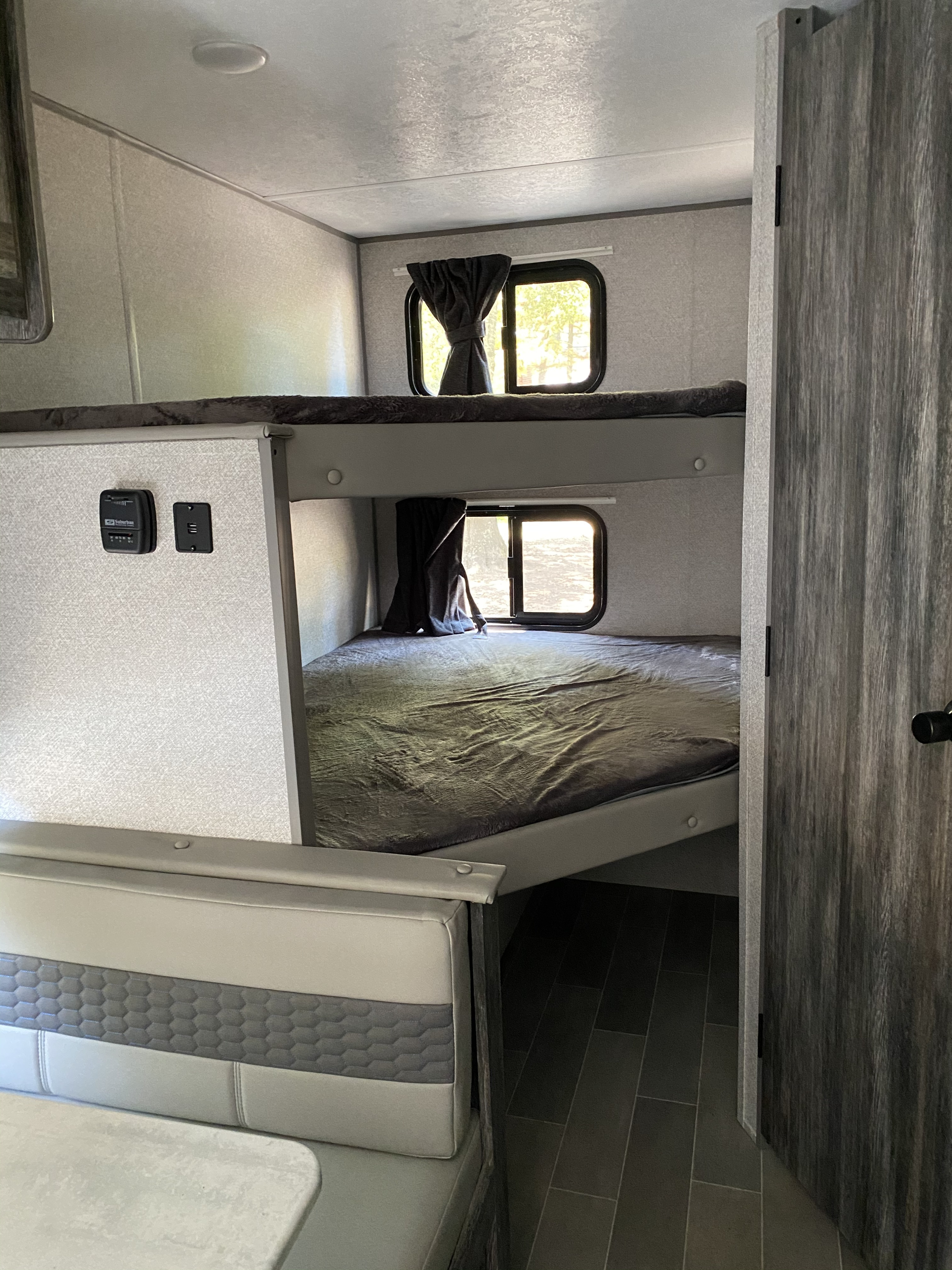 Explore this spacious RV rental interior with comfortable bunk beds, a cozy dining area, and bright windows.. Forest River Other 2021