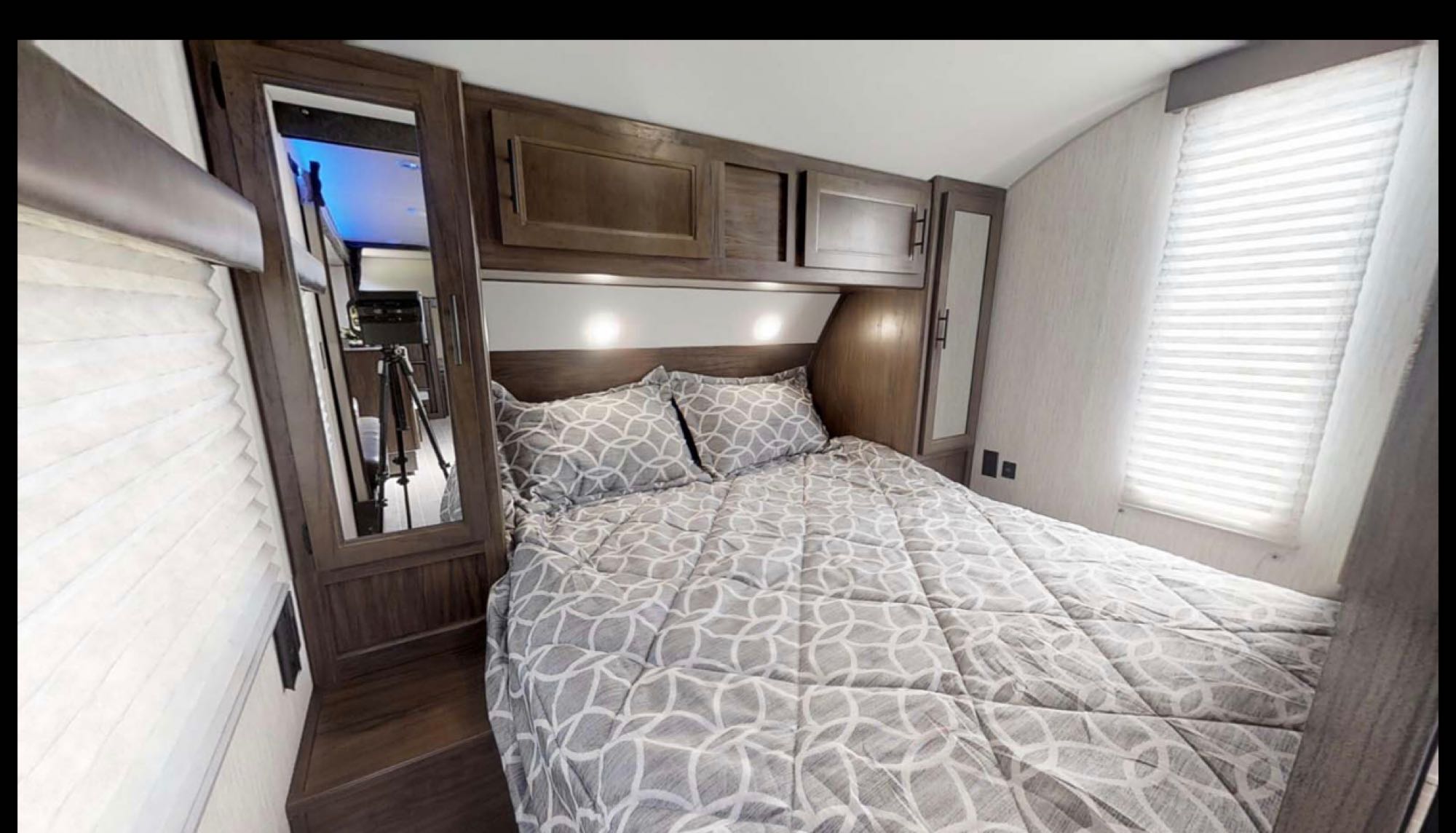 Cozy RV rental bedroom features a comfy bed, overhead storage, mirrored closets, and window with blinds.. Forest River Cherokee 2018