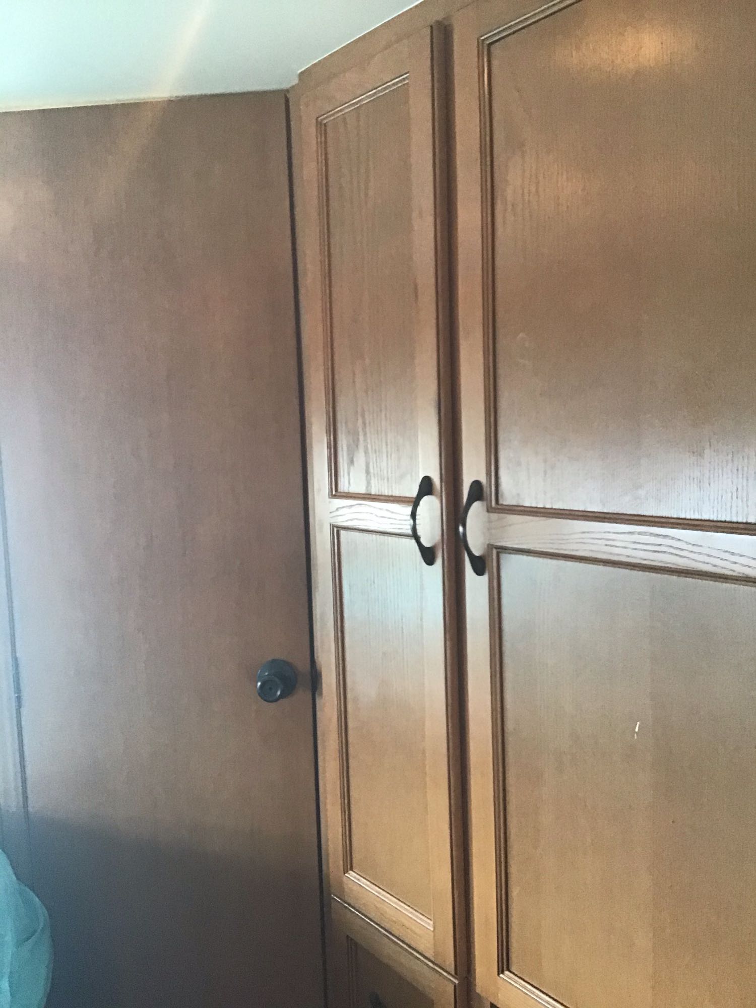 RV rental features warm wooden cabinets with black handles & a matching door. Cozy and functional RV interior design.. Other Other 2014