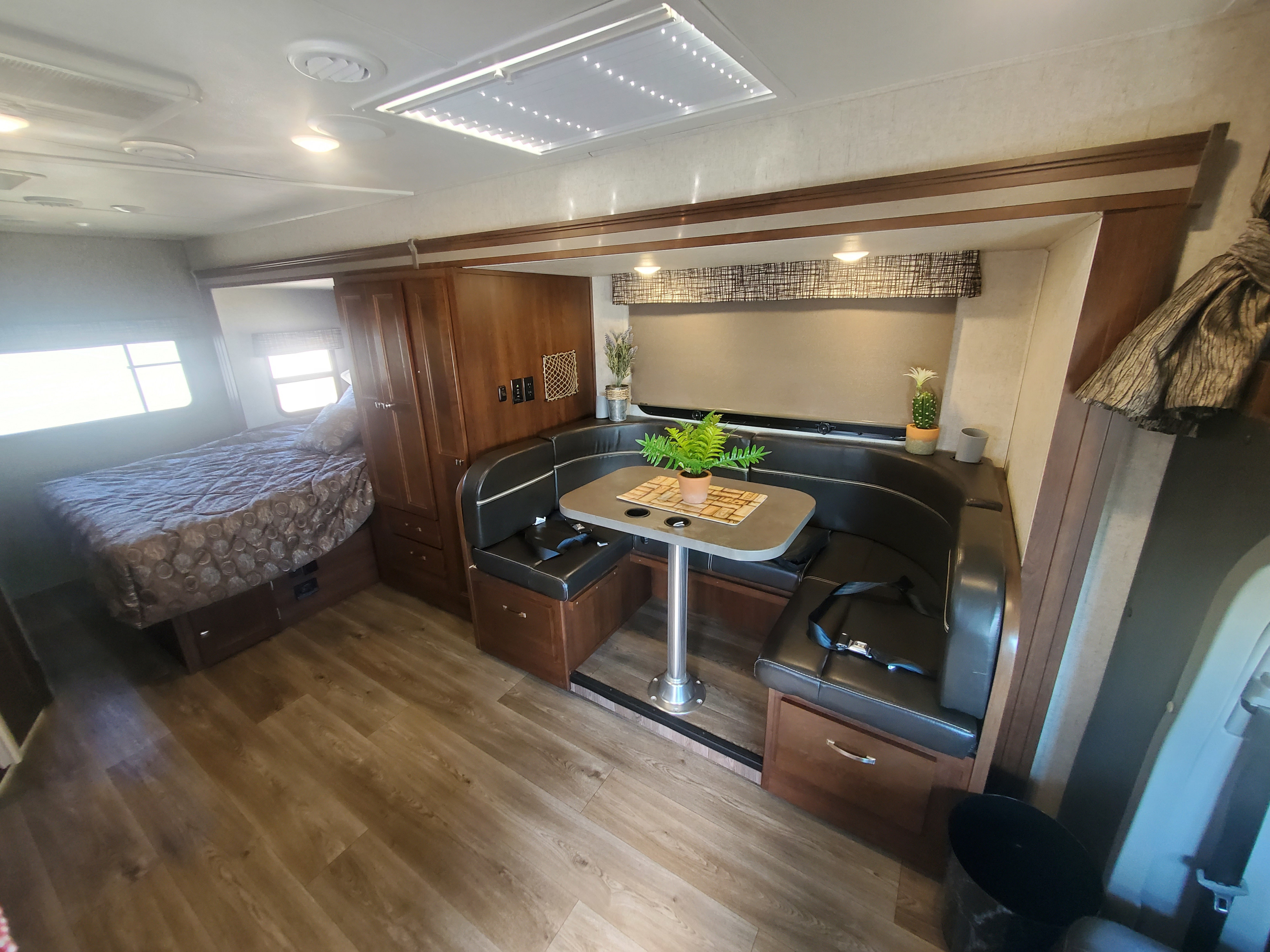 RV rental interior featuring a comfortable bed, U-shaped dinette, and modern design. Ideal for your next adventure.. Forest River Sunseeker 2018