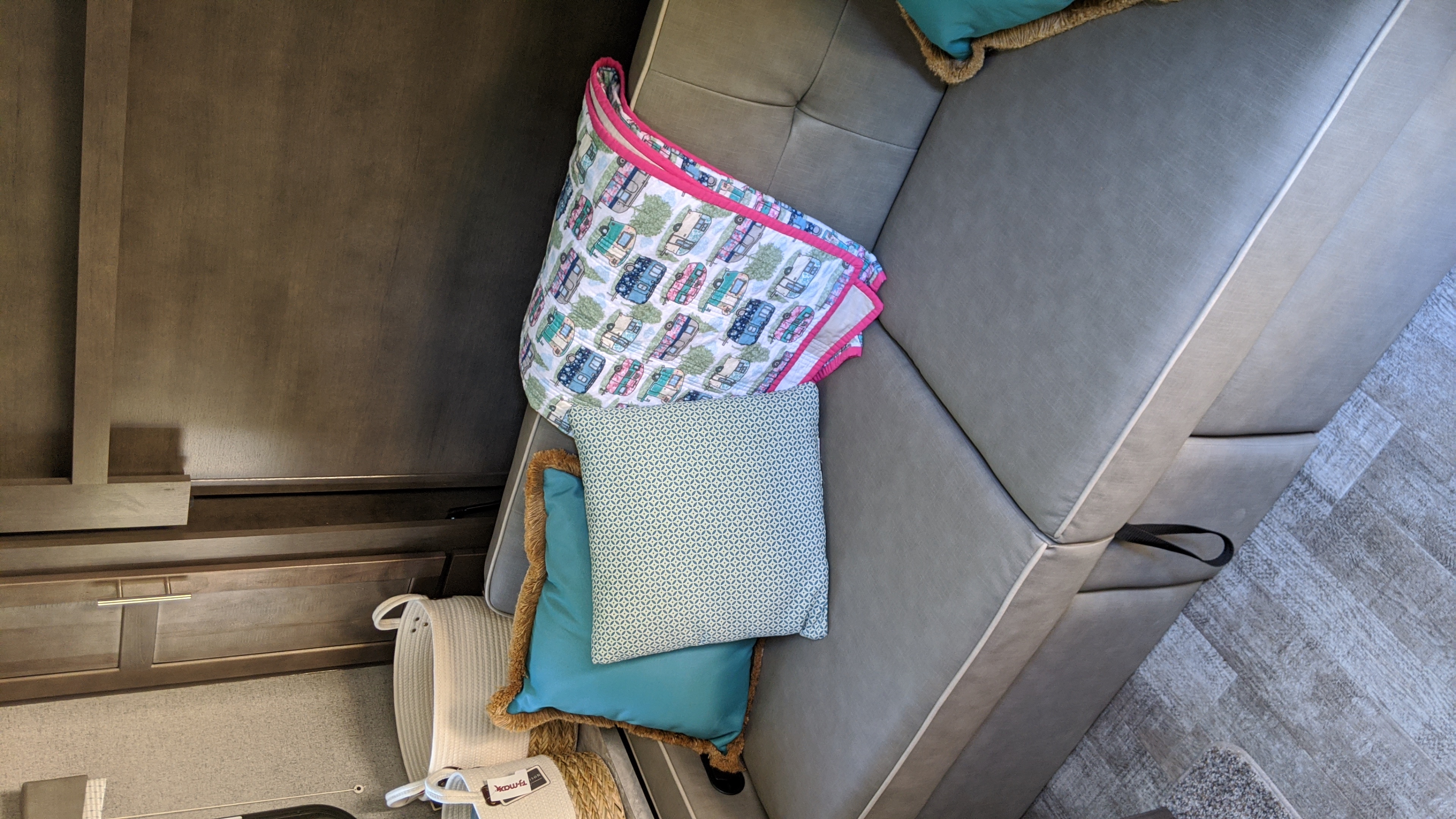 Stylish RV rental living area: gray couch, playful camper-themed blanket, and decorative pillows.. Forest River Rockwood Mini Lite 2020