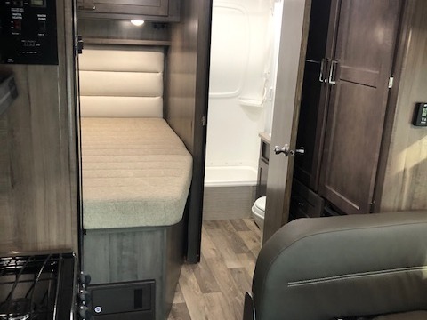 Cozy bed, compact kitchen, and bathroom with shower/toilet in an RV rental. Modern interior with storage & seating.. Winnebago Minnie Winnie 2020