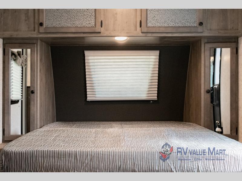 RV rental interior: bedroom featuring a comfortable bed, storage cabinets, and a privacy window.. Coachmen Apex 2021