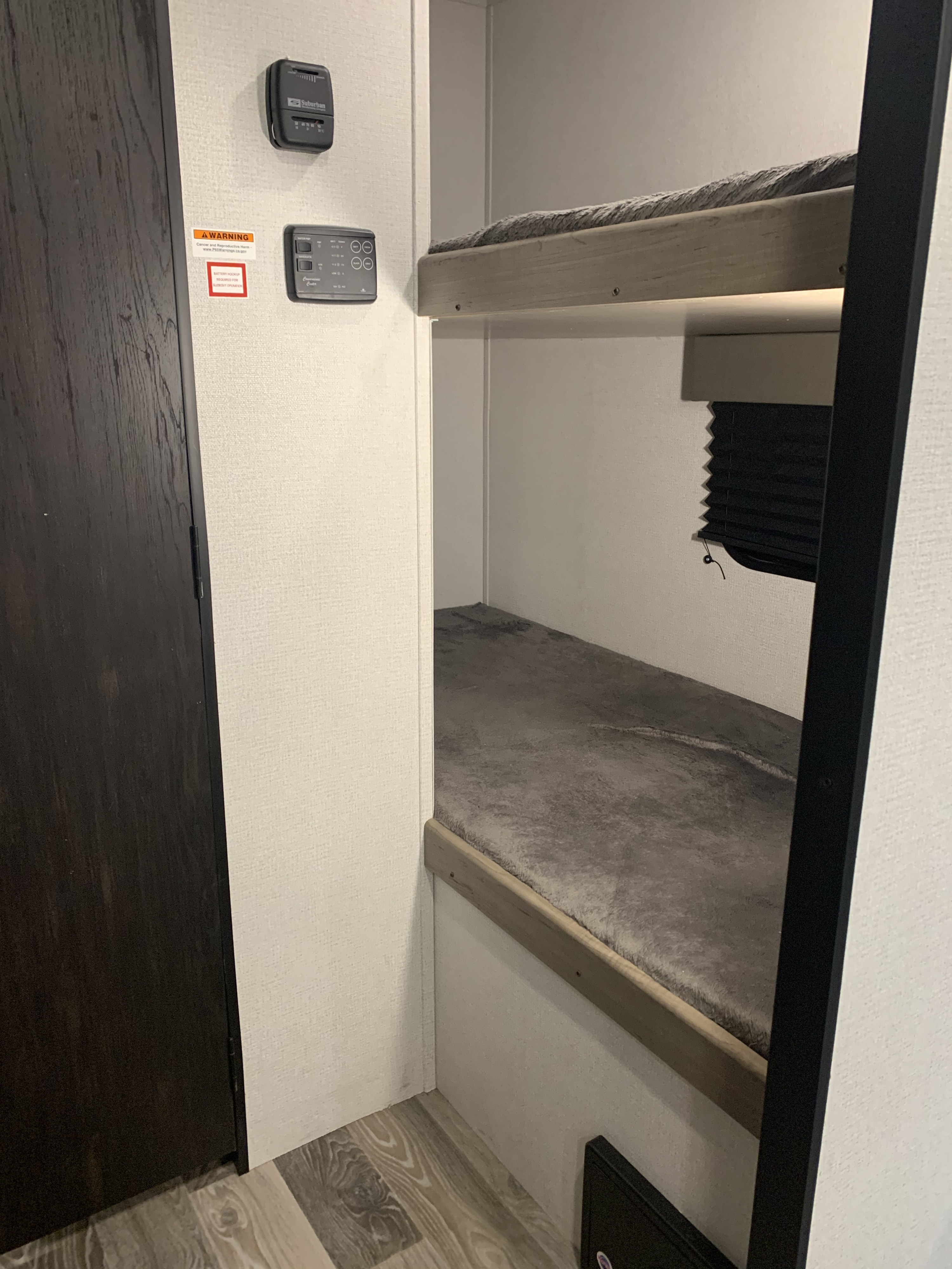 Inside an RV rental: cozy bunk beds, climate controls, and a door. Perfect for family adventures.. Keystone Hideout 2021