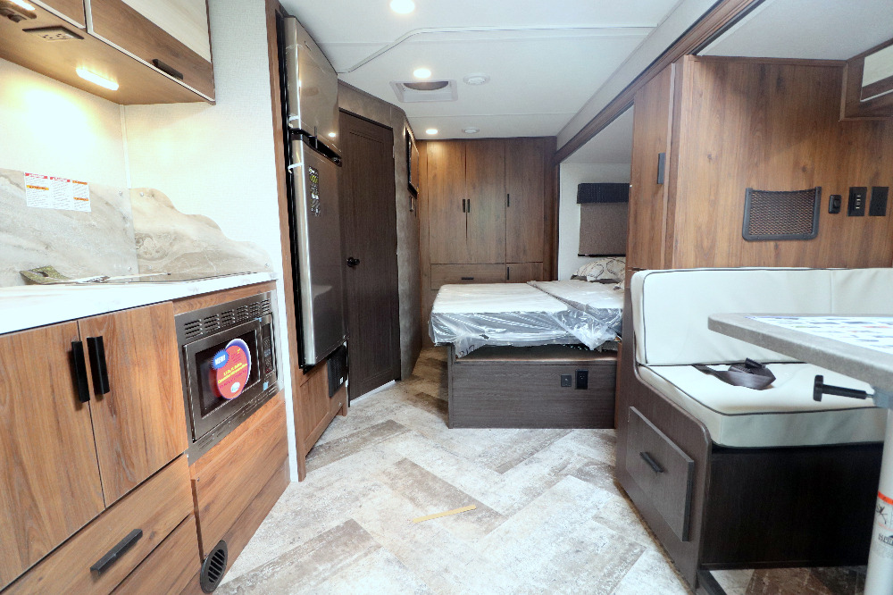 This RV rental interior features a compact kitchen, comfortable bed, and dinette area for enjoyable travel.. Forest River Forester 2021