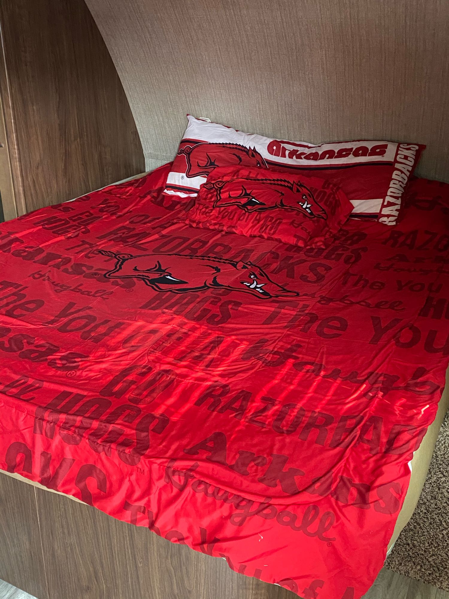 Arkansas Razorbacks themed bedding inside an RV rental, offering a cozy, fan-friendly travel space.. Dutchmen Aerolite 2017