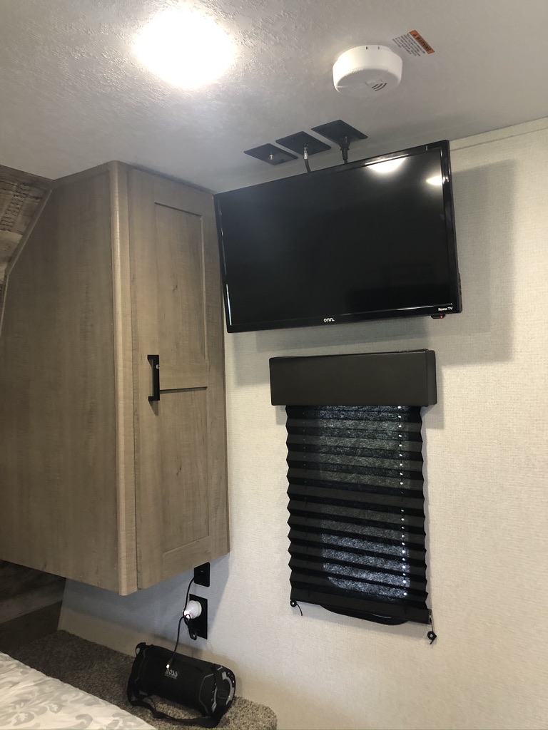 RV rental bedroom: TV, cabinet, window blind & safety alarm for comfortable, compact travel.. Keystone RV Hideout 2021