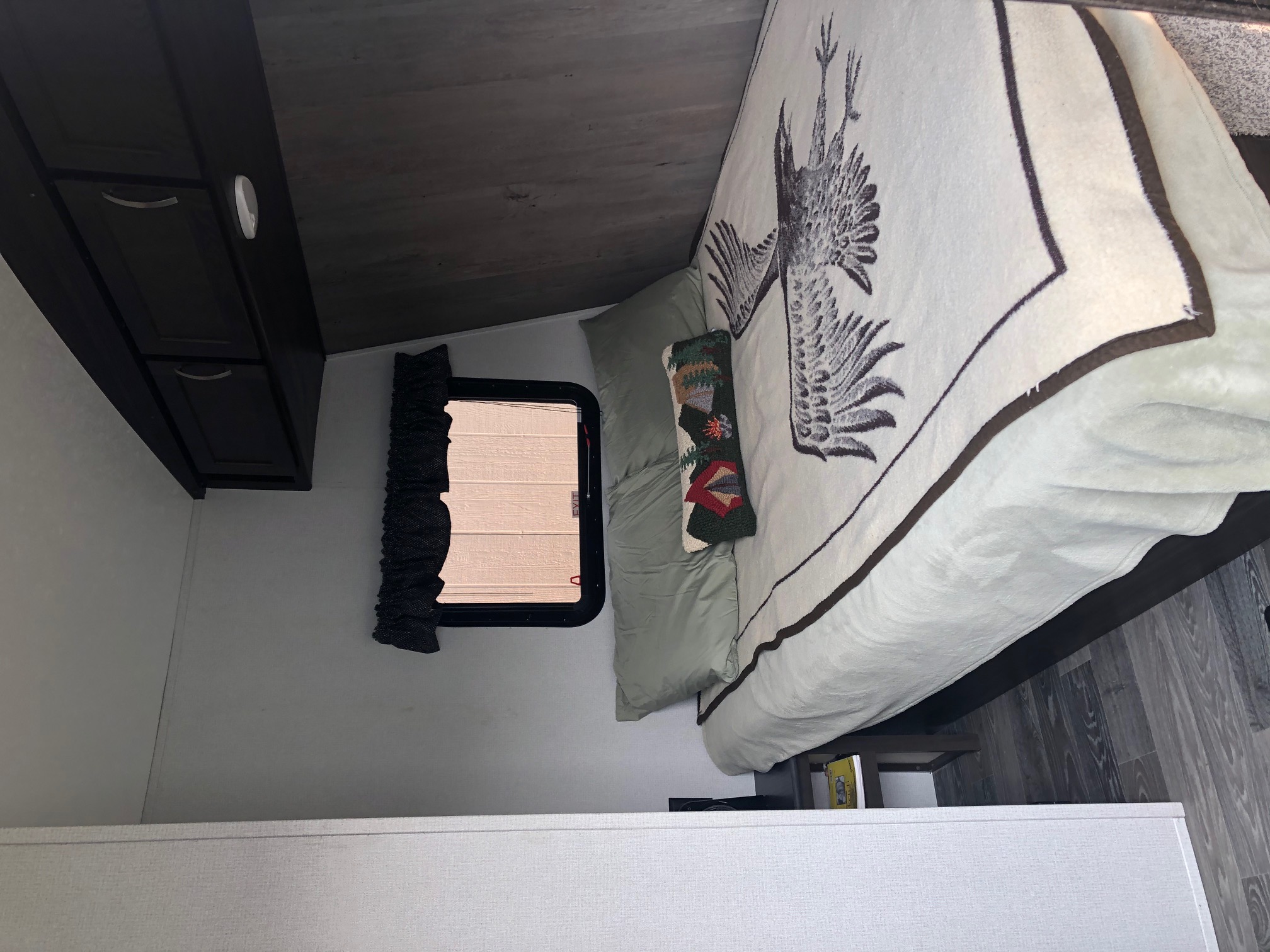 Cozy RV bedroom interior with bird-patterned blanket, perfect for your next RV rental adventure.. Keystone Springdale 2020