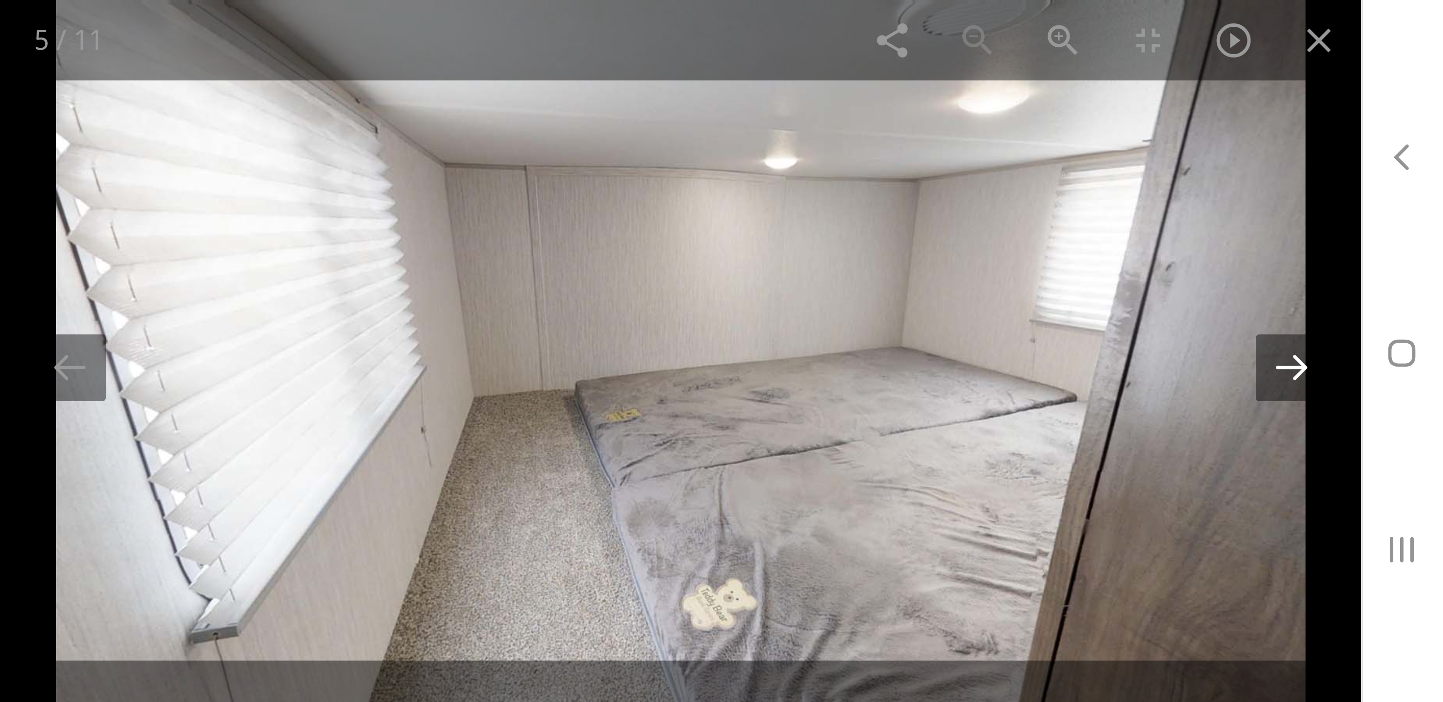 RV rental interior: compact bedroom with grey floor mattress, white pleated blinds, and cozy lighting.. forest river cherokee 39ca 2019