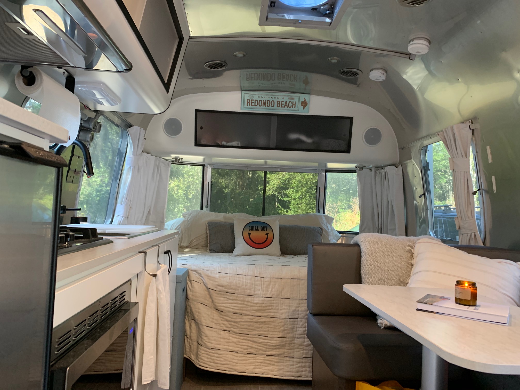 Cozy Airstream RV rental interior, featuring a bed, compact kitchen, and dining area, ideal for a relaxing getaway.. Airstream Other 2020