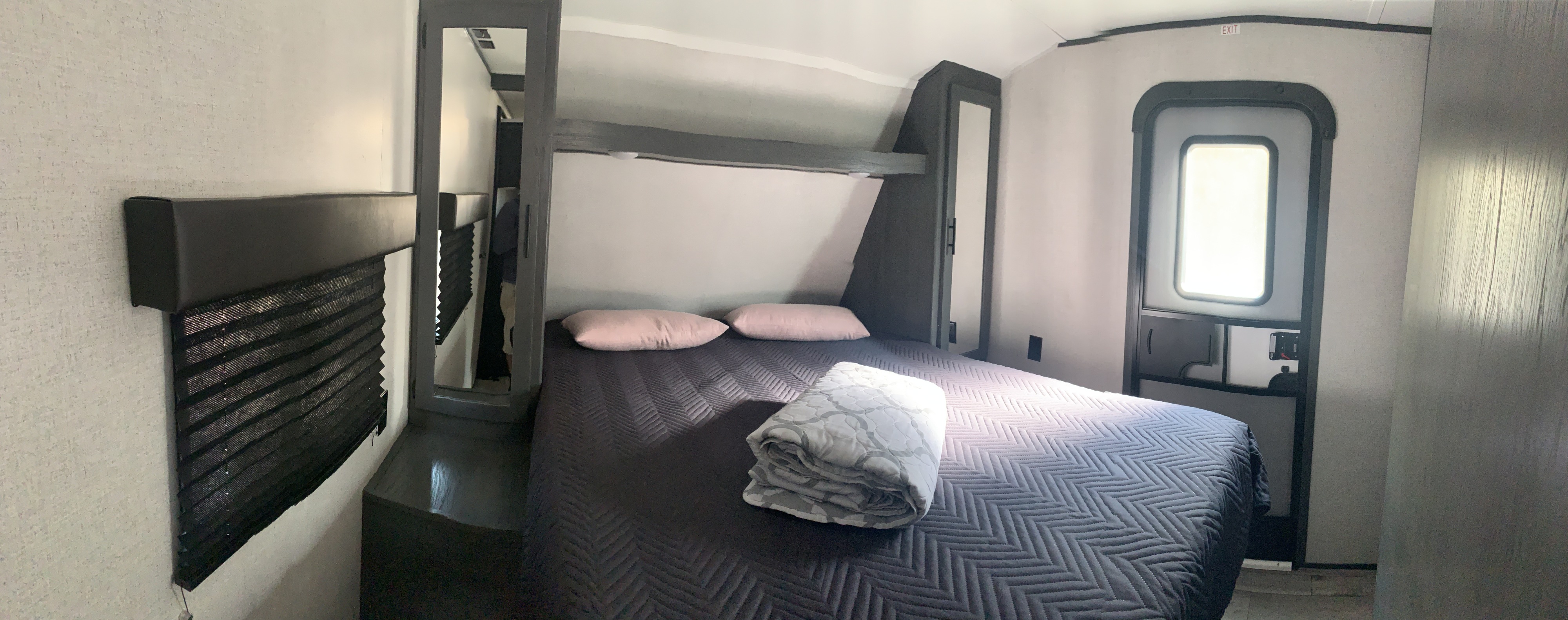 Cozy RV rental bedroom with a comfy bed, built-in storage, and bright natural light. Perfect for travel.. Dutchmen Aspen Trail 2021