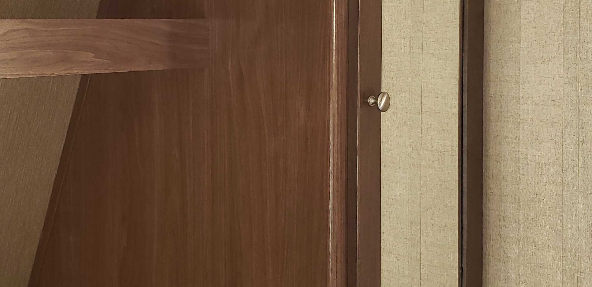 Warm wood cabinetry, a small knob, and textured wall paneling in an RV rental interior. Detailed and inviting.. Coleman Coleman 202RD 2017