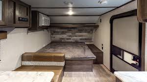 **RV rental interior**: A cozy, compact space with a bed, dinette, and air conditioner visible, perfect for adventurers.. Dutchmen Coleman Lantern LT 2020