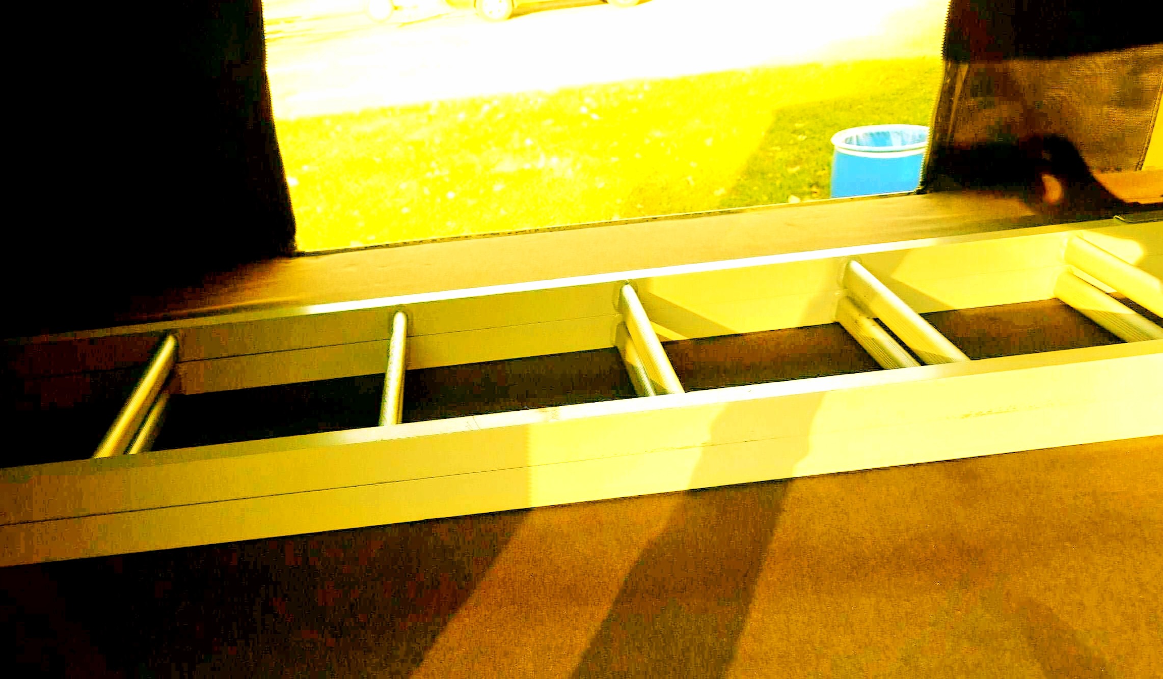 RV rental interior: Built-in ladder for bunk access, next to a sunlit window showing green grass and a blue bucket.. Dodge Grand Caravan 2014