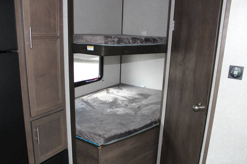 RV rental: Compact camper interior with bunk beds, storage cabinetry, and a control panel for comfortable stays.. Coleman Other 2021