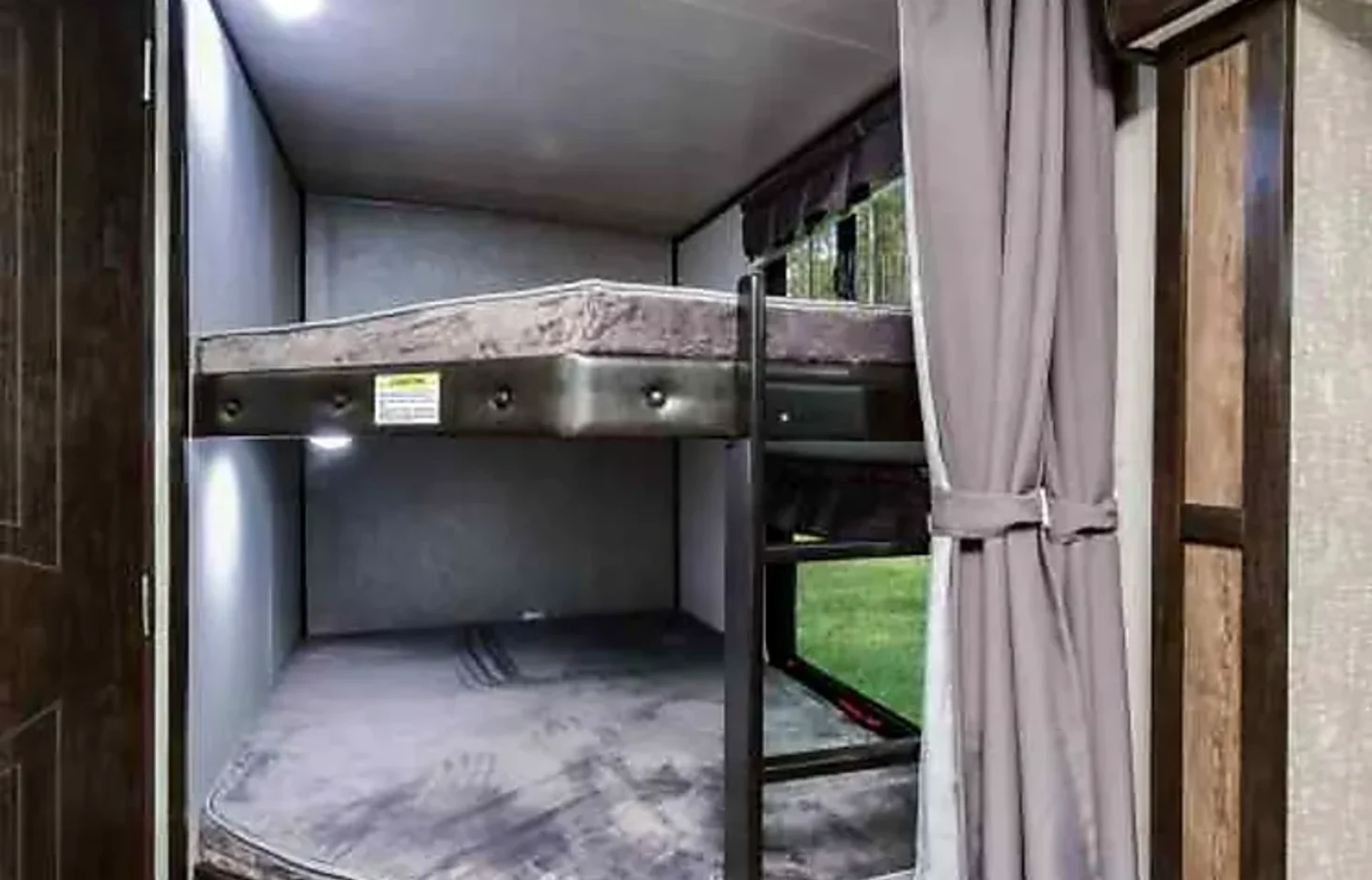 RV rental bunk beds, perfect for family adventures. Cozy interior with built-in lights & window view.. Heartland Mallard 2019