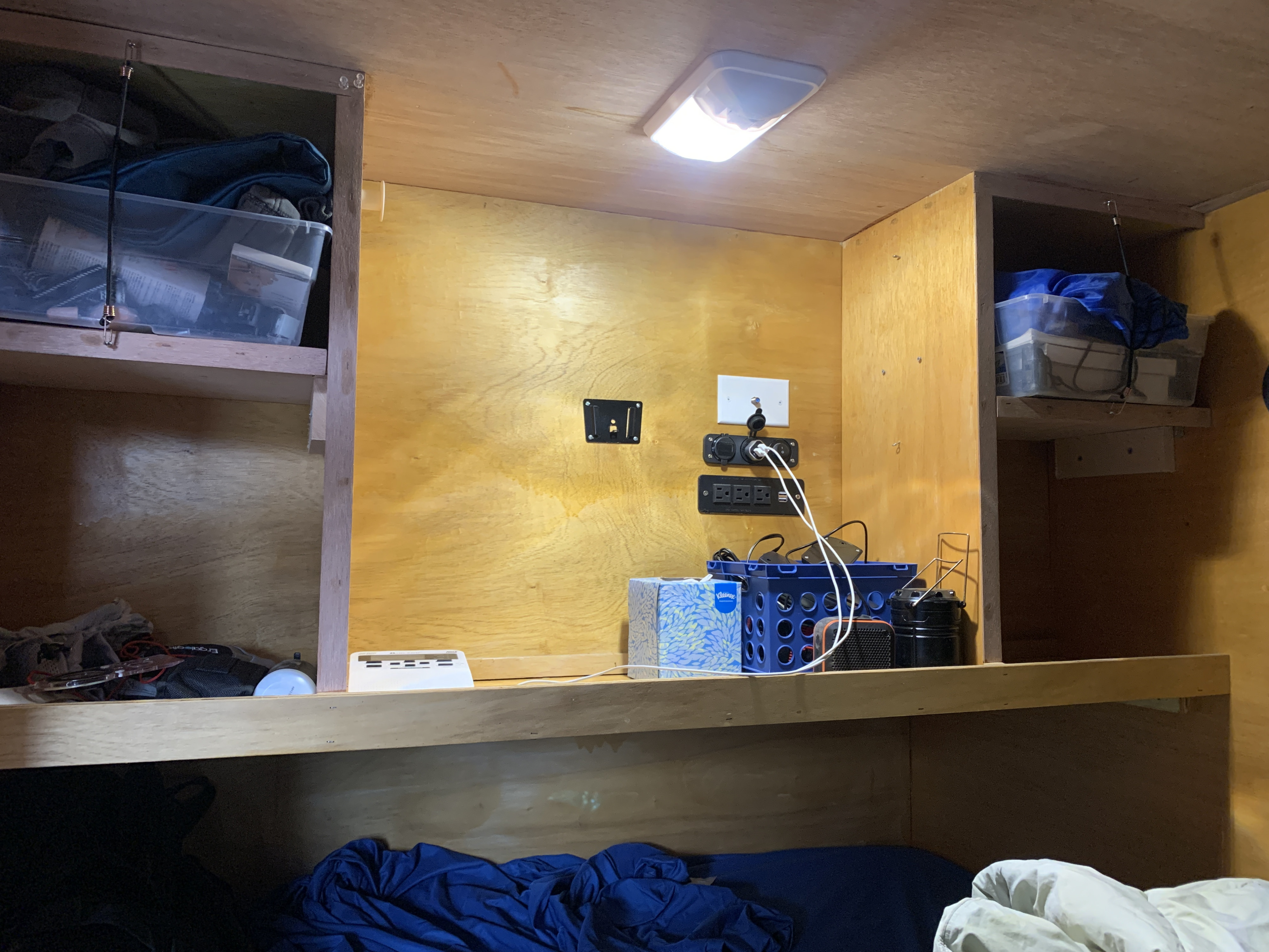 RV rental interior: bunk bed with storage shelves, a bright ceiling light, and a wall-mounted charging station.. Little Guy Other 2020