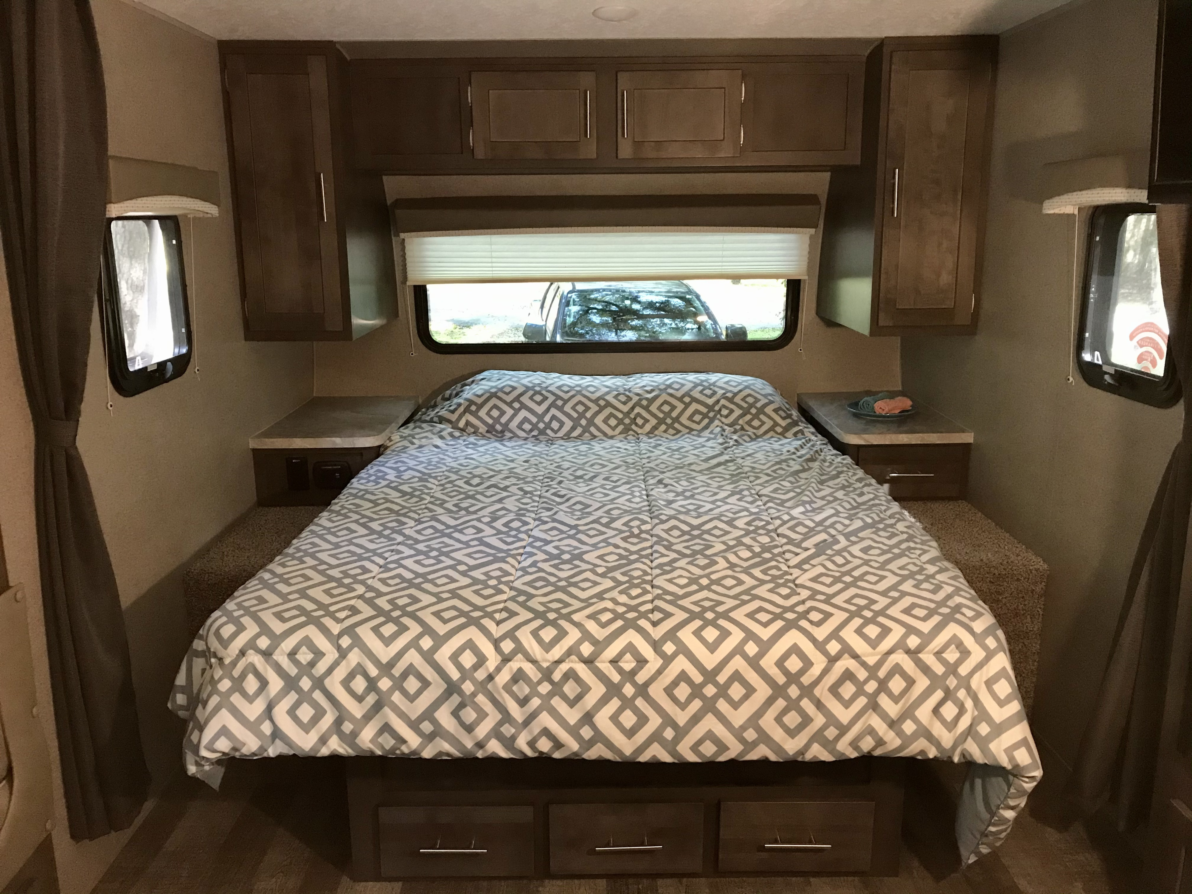Cozy RV rental bedroom featuring a patterned comforter, overhead. Forest River Mini-Lite 2020