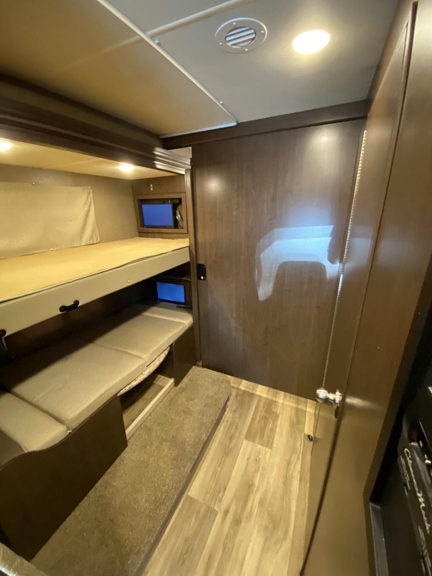 Cozy RV rental interior with bunk beds, individual TVs, and compact seating. Perfect for family travel.. Thor Motor Coach Freedom Elite 2019