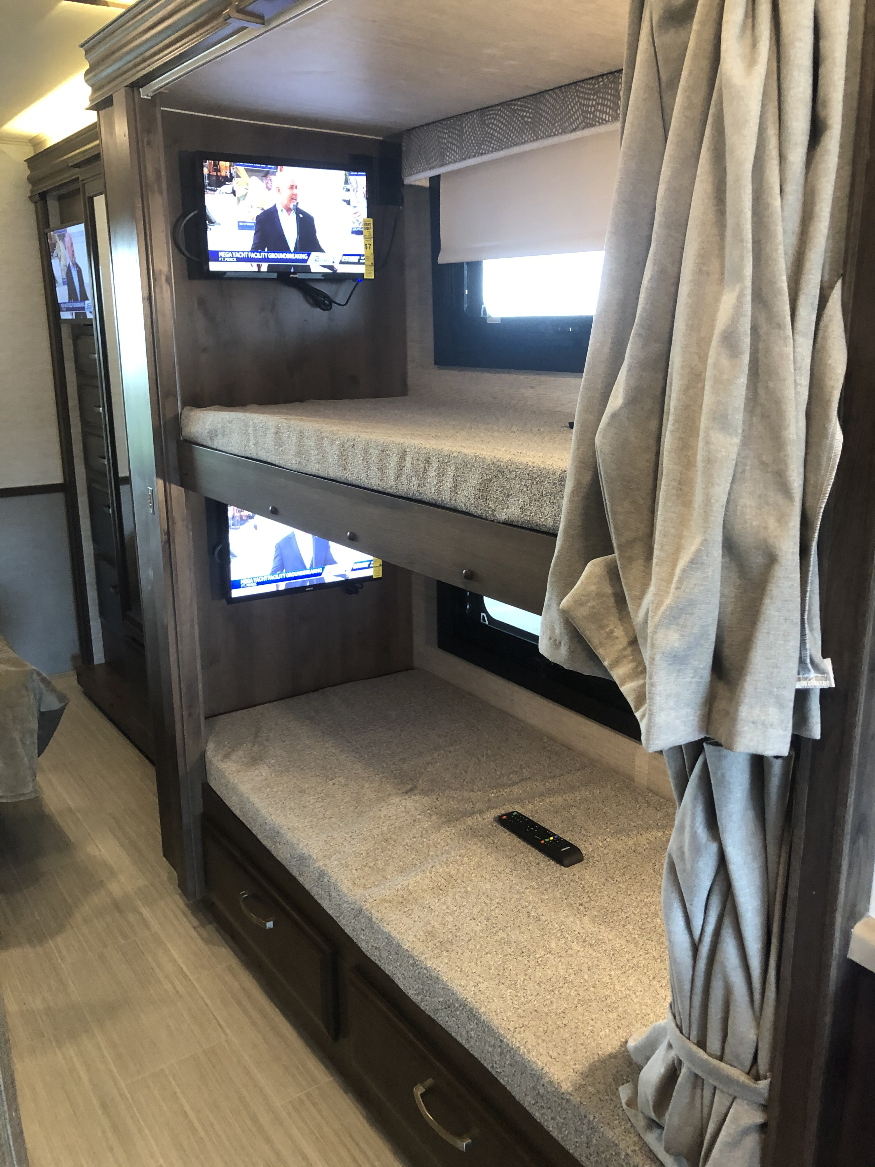 Cozy RV rental bunk beds with individual TVs and window blinds. Perfect for family trips with entertainment.. Entegra Coach Vision 29F 2021