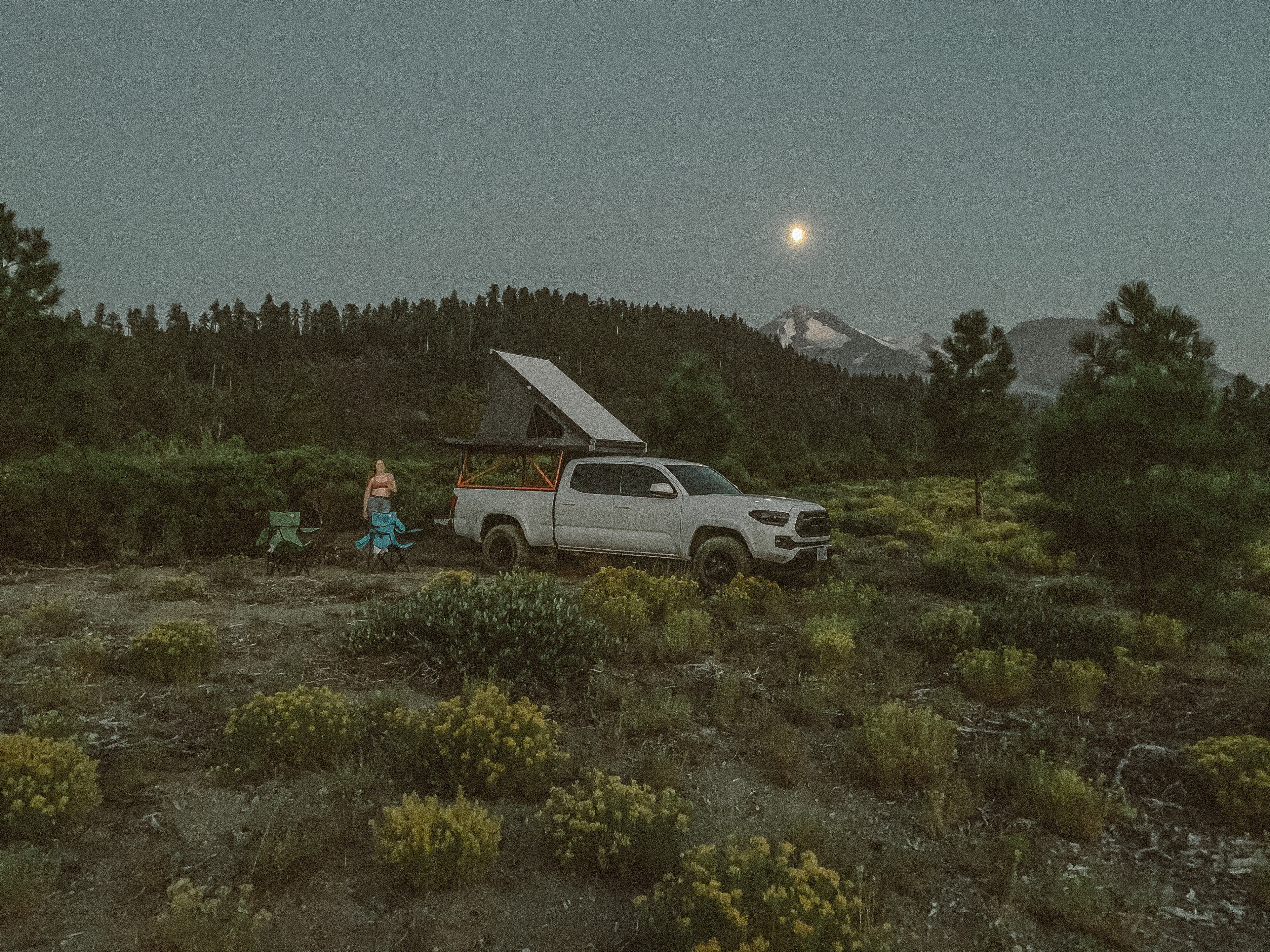 Moonlit outdoor camping with a truck camper, ideal for an RV rental adventure by snow-capped mountains.. Other Other 2019