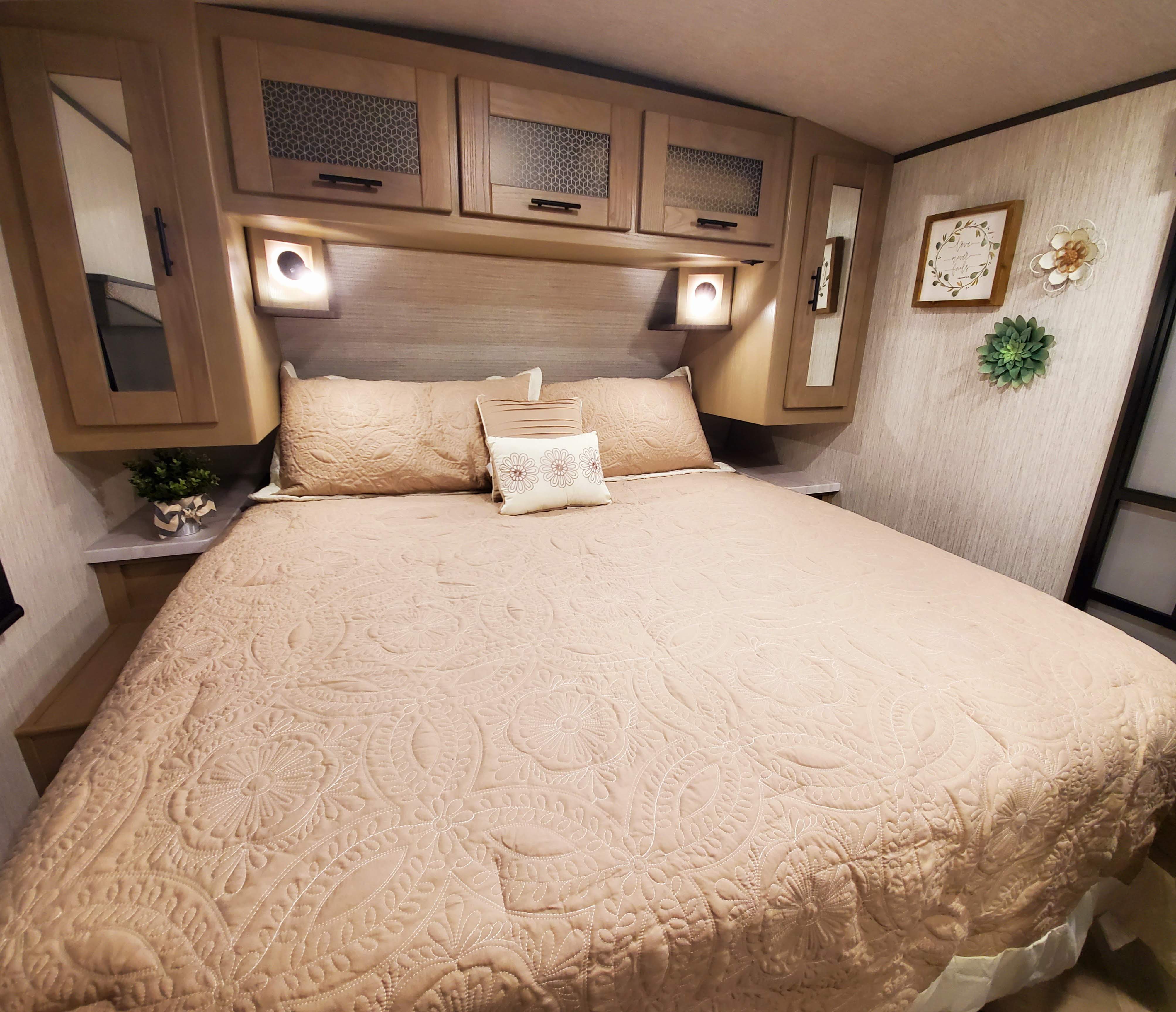 Cozy RV rental bedroom features a quilted bed, overhead cabinets, and inviting decor for a comfortable stay.. Cruiser Rv Corp Cruiser 2021
