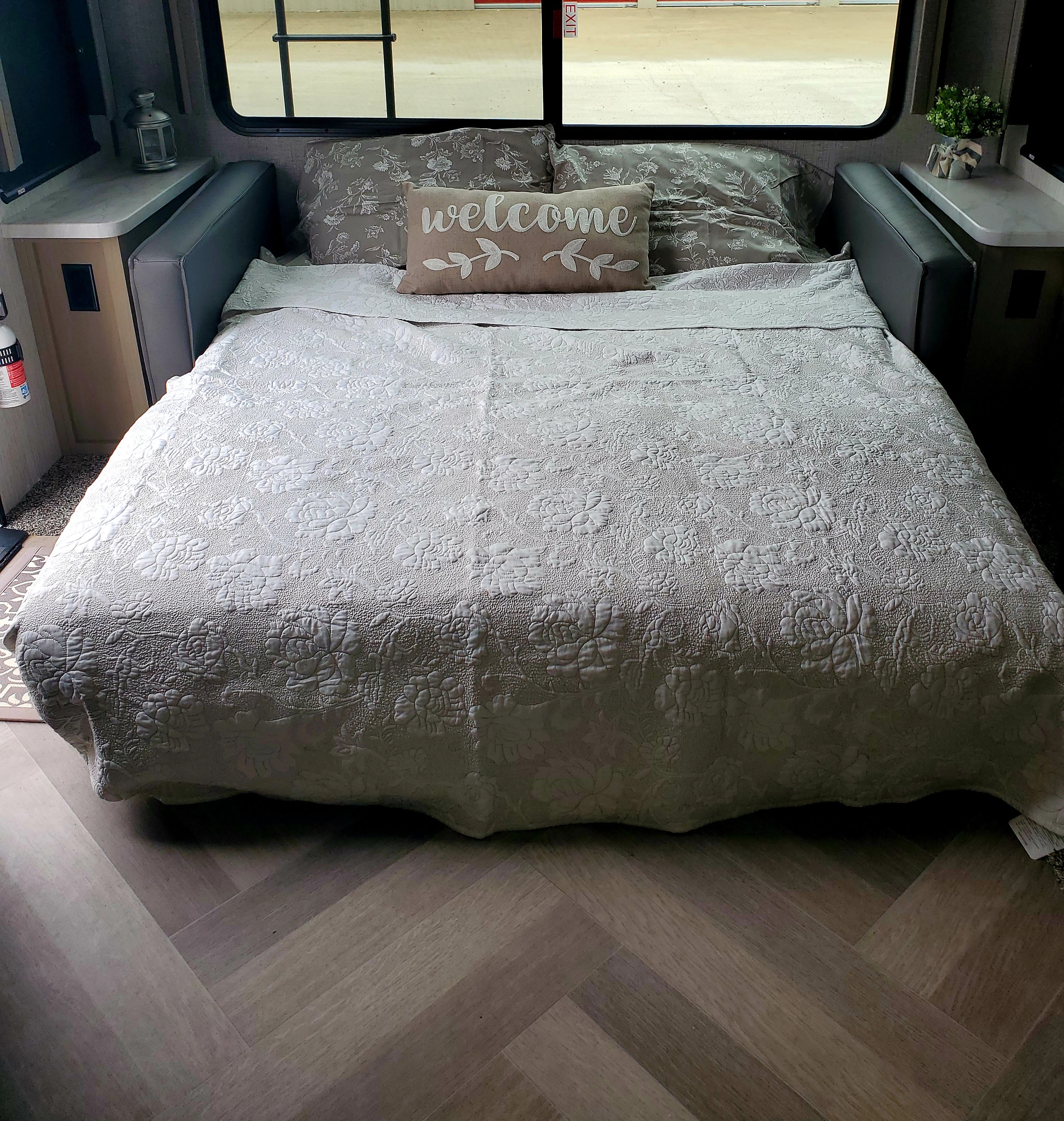 Cozy RV rental bedroom featuring a plush quilted bed with a 'WELCOME' pillow, perfect for relaxing on your trip.. Cruiser Rv Corp Cruiser 2021