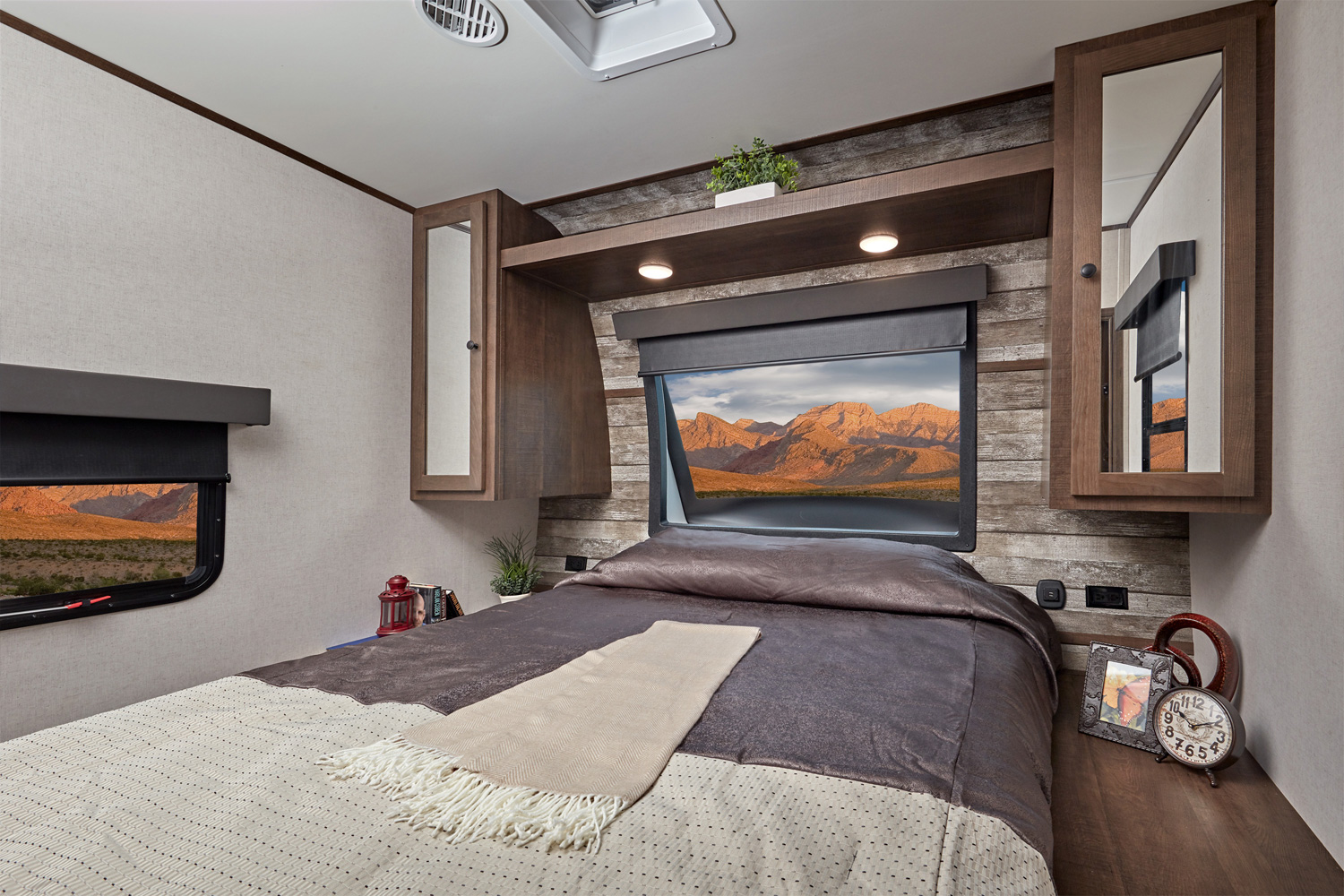 Spacious RV rental bedroom with a comfortable bed, ample storage cabinets, and a large window showing desert mountains.. Forest River 2815 XLR HyperLite 2021