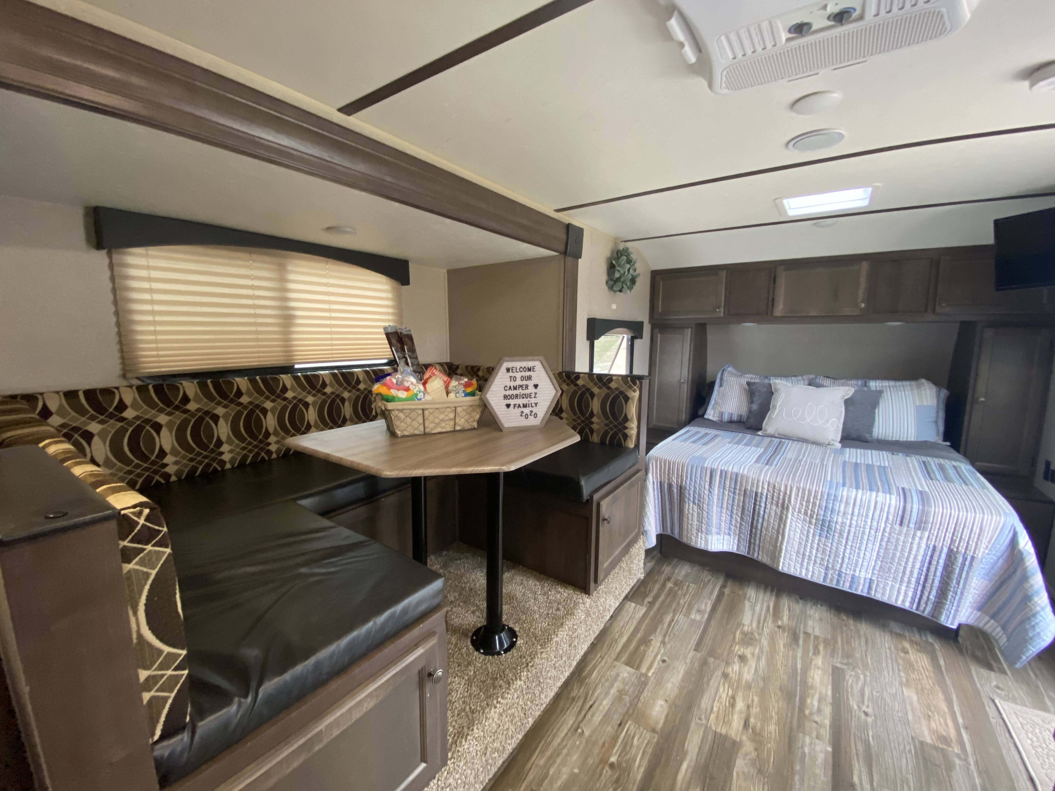 Inviting RV rental interior showcasing a spacious dinette with snacks & a comfortable bed, ready for your adventure.. Other Sun-Lite 2019