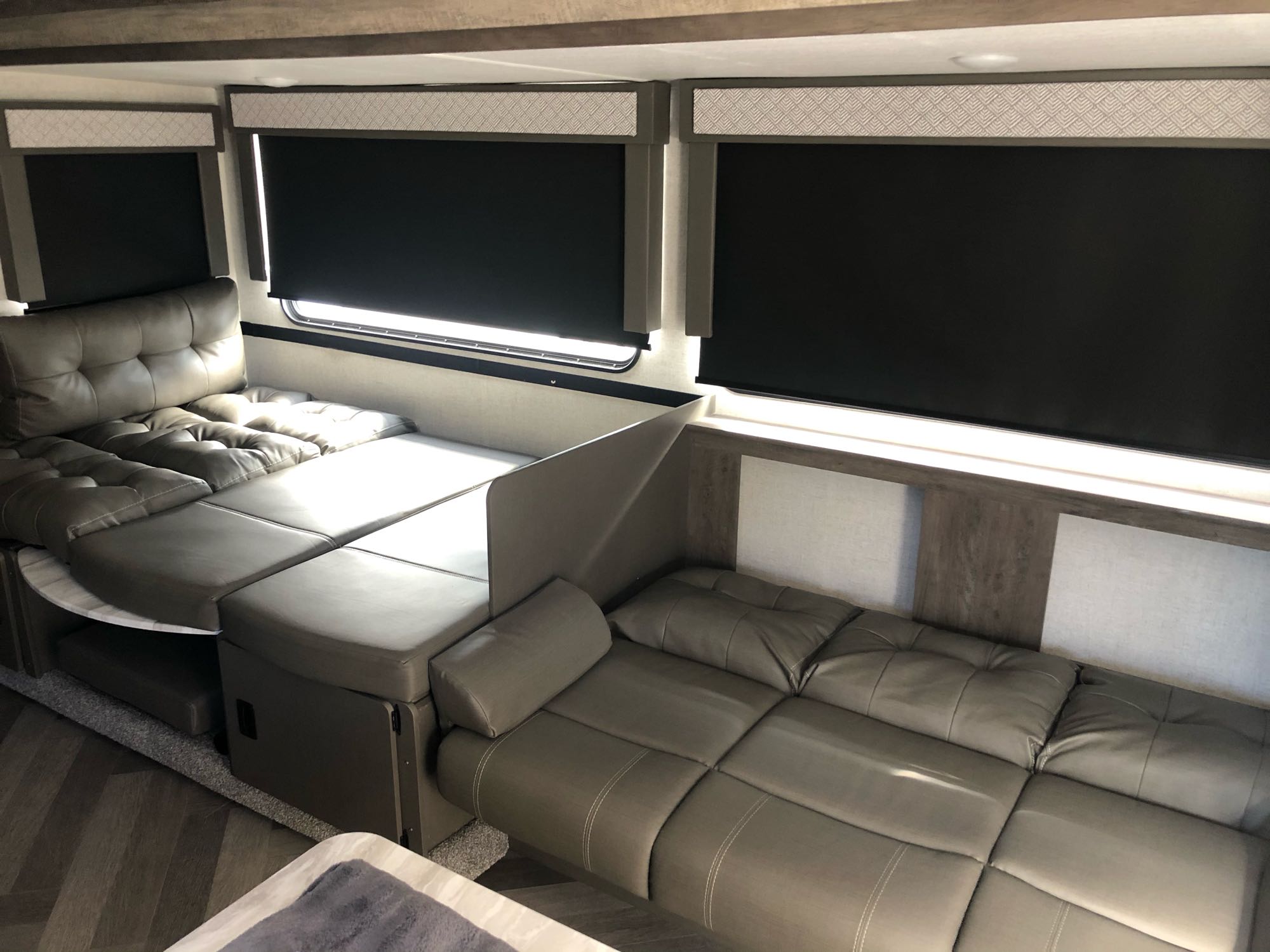 Spacious RV rental interior with modern convertible seating and privacy blinds for comfortable living and sleeping.. Forest River Wildwood X-Lite 2021