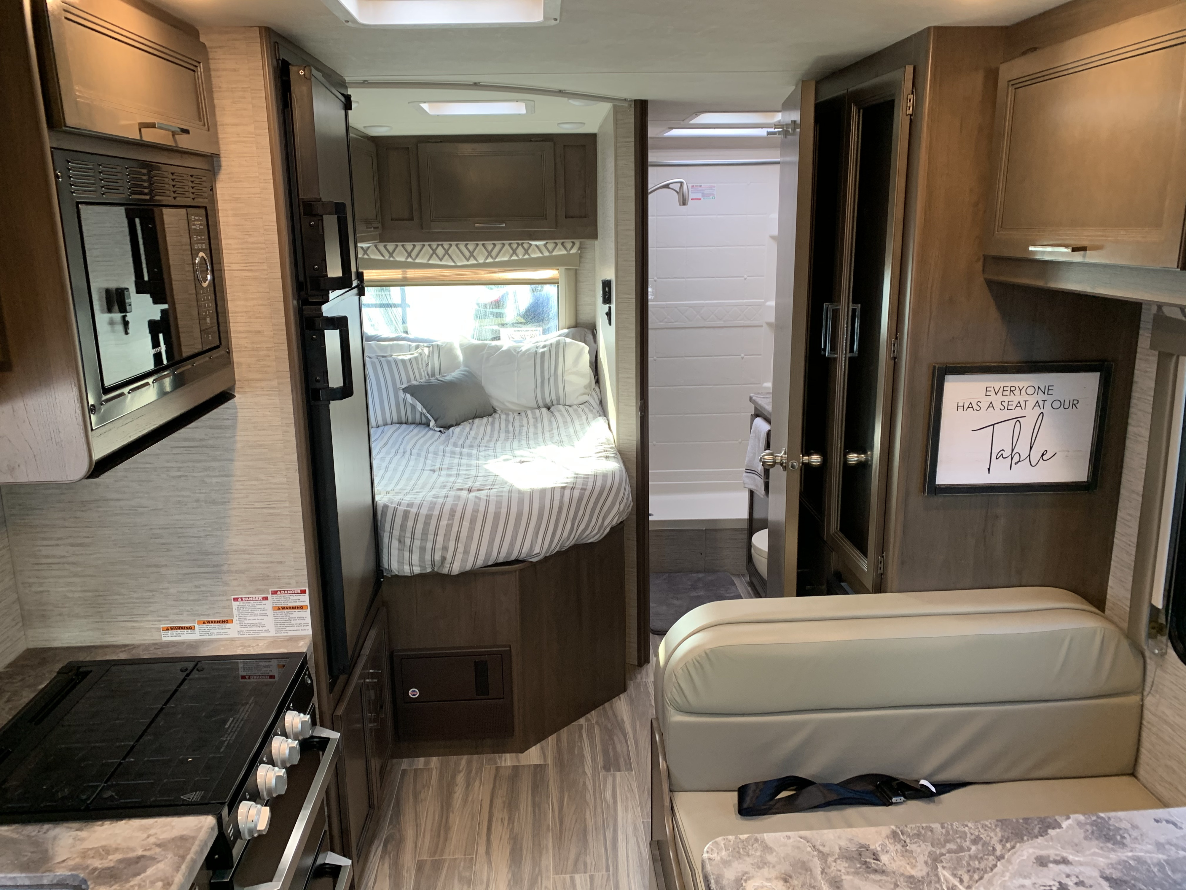 Spacious RV rental interior with kitchen, cozy bedroom, full bathroom, and dinette seating. Perfect for adventure!. Thor Motor Coach Four Winds 2021