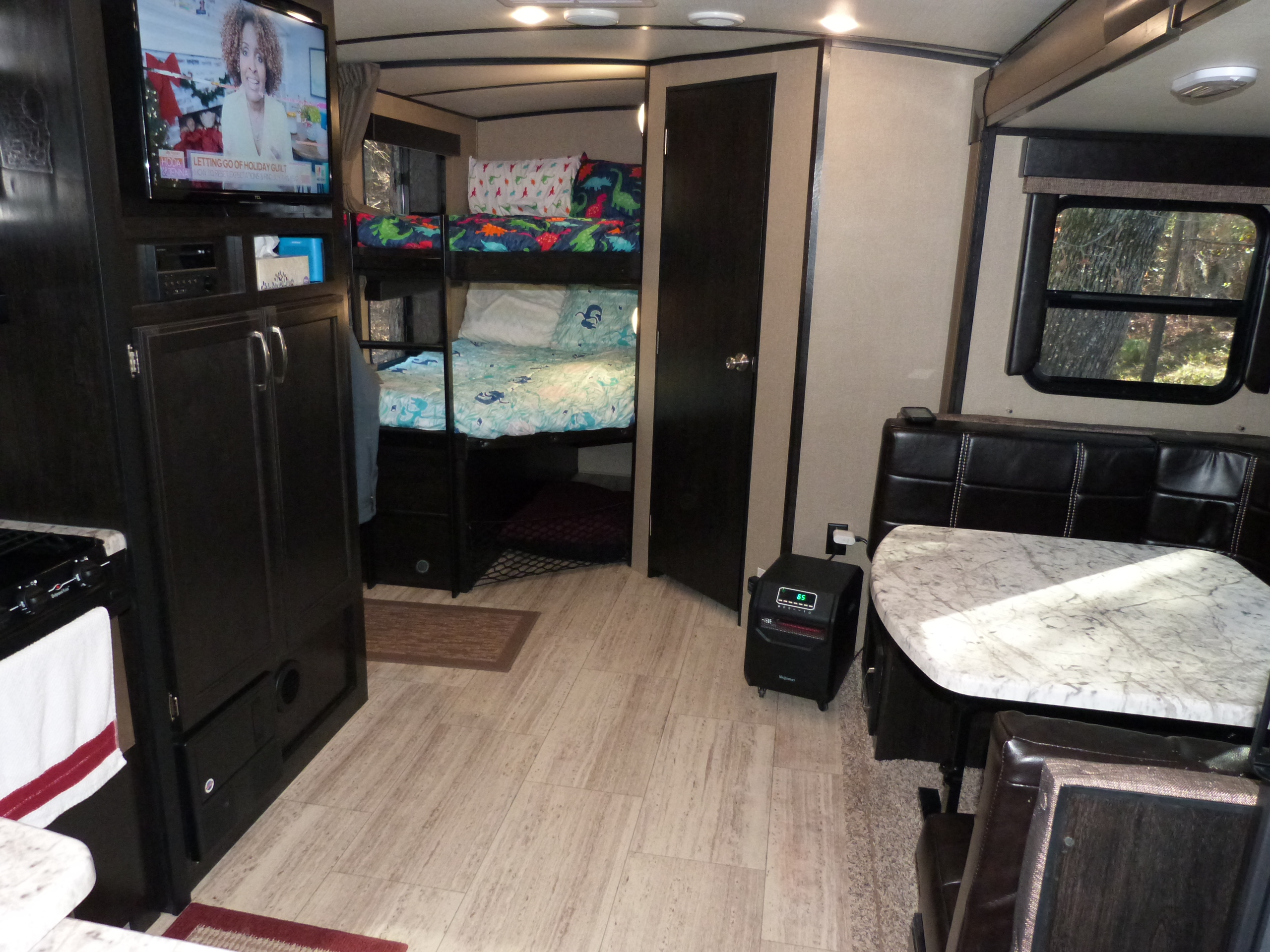Cozy rv rental interior featuring bunk beds with themed bedding, a dinette, kitchen, and TV. Great for family adventures.. Grand Design 2400BH 2017
