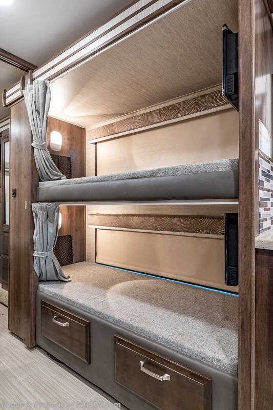 Cozy RV rental interior featuring comfortable bunk beds with privacy curtains and individual lighting. Perfect for family adventures.. Entegra Coach Other 2021