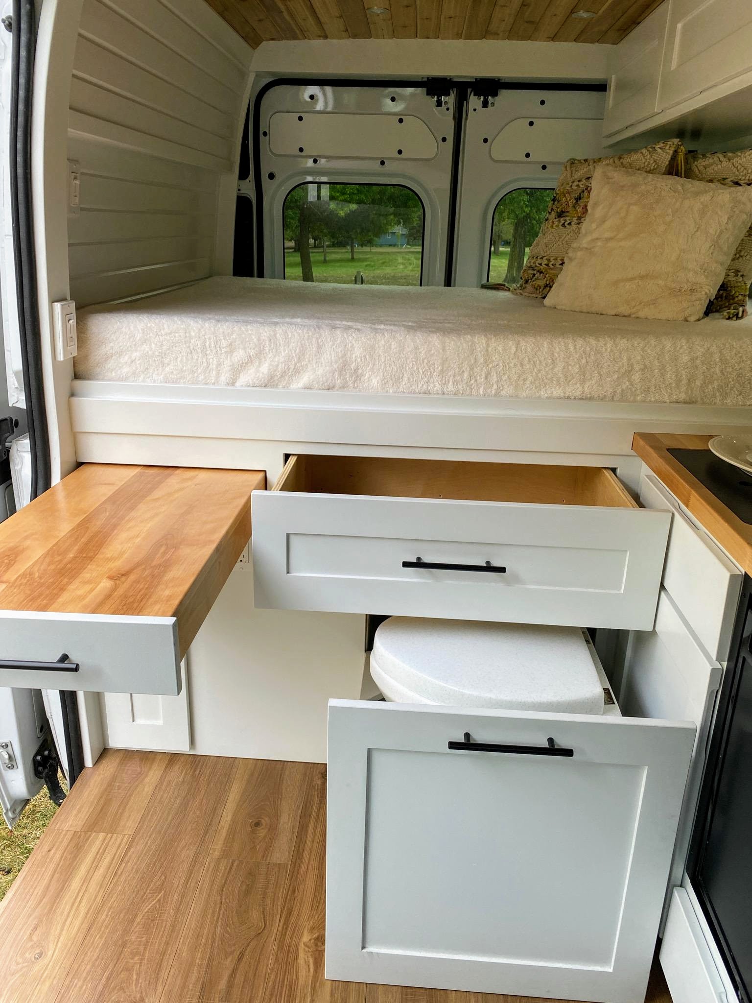This cozy rv rental campervan features a bed, pull-out table, smart storage, and discreet toilet for comfortable mobile living.. Ram ProMaster 2019