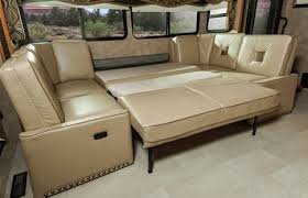 RV rental interior: A versatile light tan sectional sofa converted into a spacious flat bed.. Winnebago Sightseer 2015