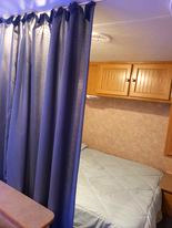 Privacy curtain pulled for full size bedroom. Dutchmen Sport 2004