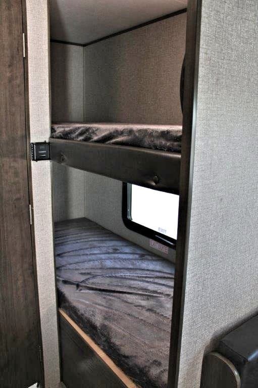 RV rental bunk beds: cozy sleeping setup with mattresses. Lower bunk features an emergency exit window for safety.. Jayco Jay Flight 2021