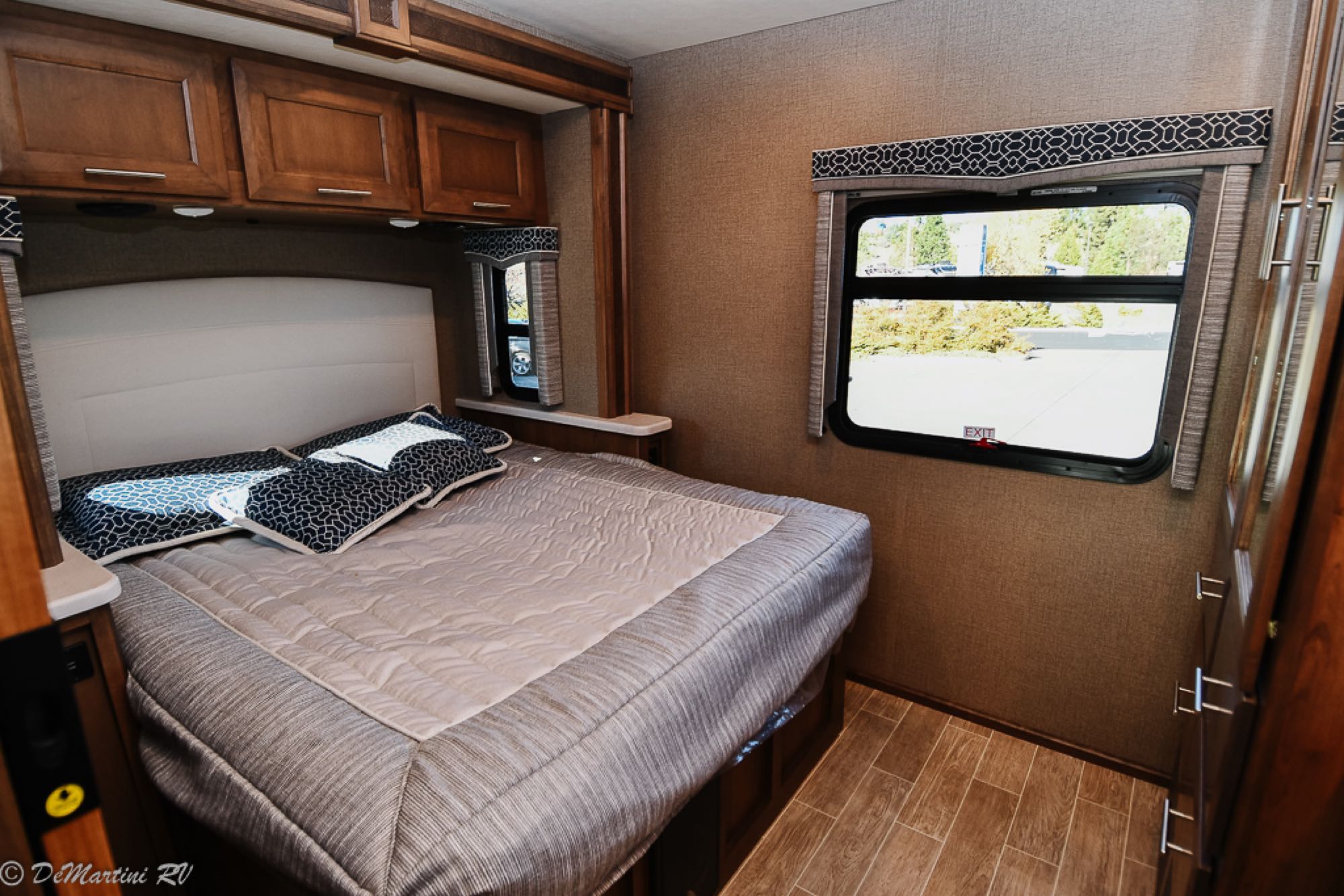 Comfortable RV rental bedroom with a large bed, overhead storage, and two windows, ideal for travel.. Thor Motor Coach Other 2021