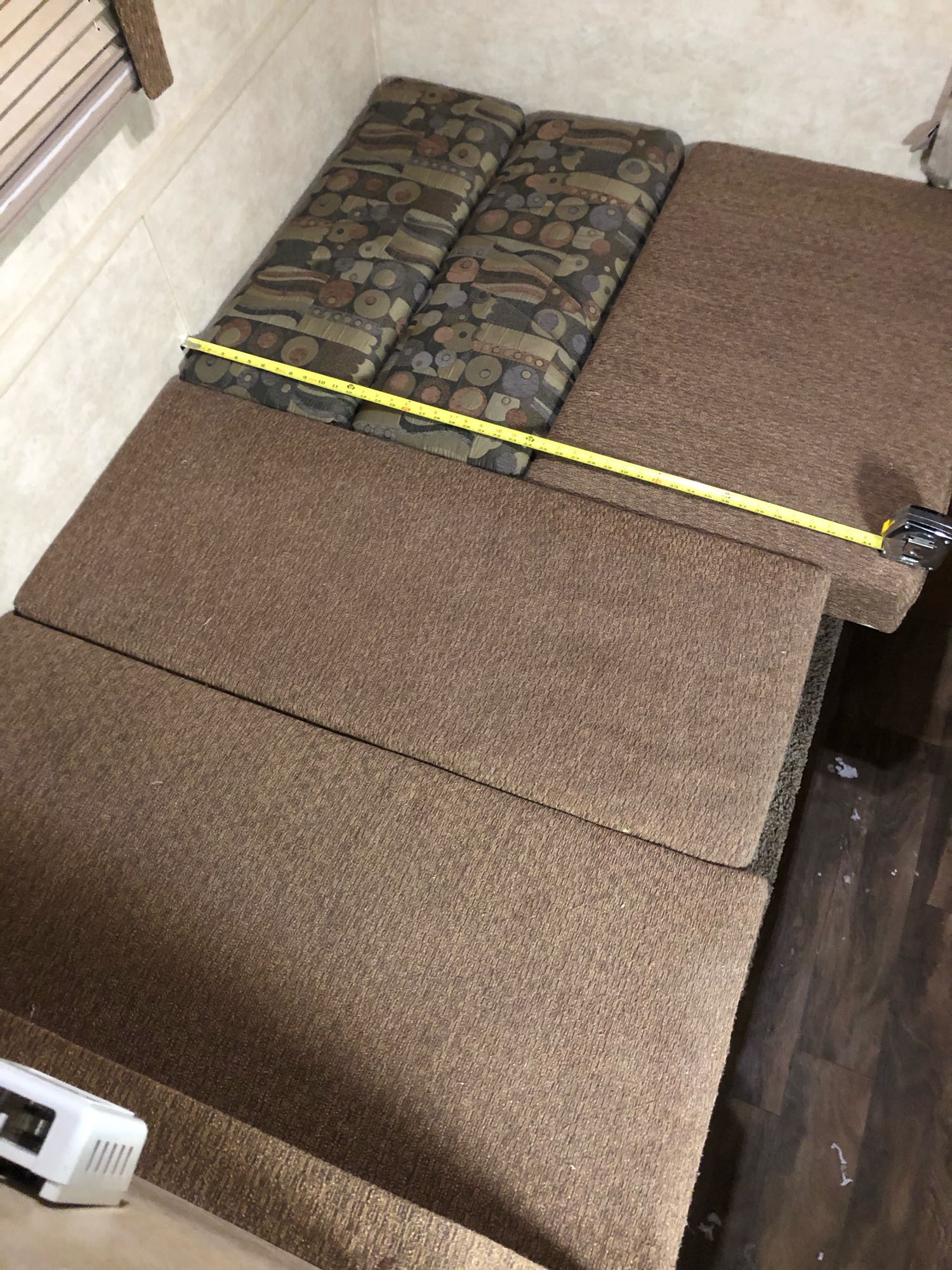 RV rental convertible seating depth measured at ~50 inches, with patterned and solid brown cushions.. Bigfoot 1500series 2018