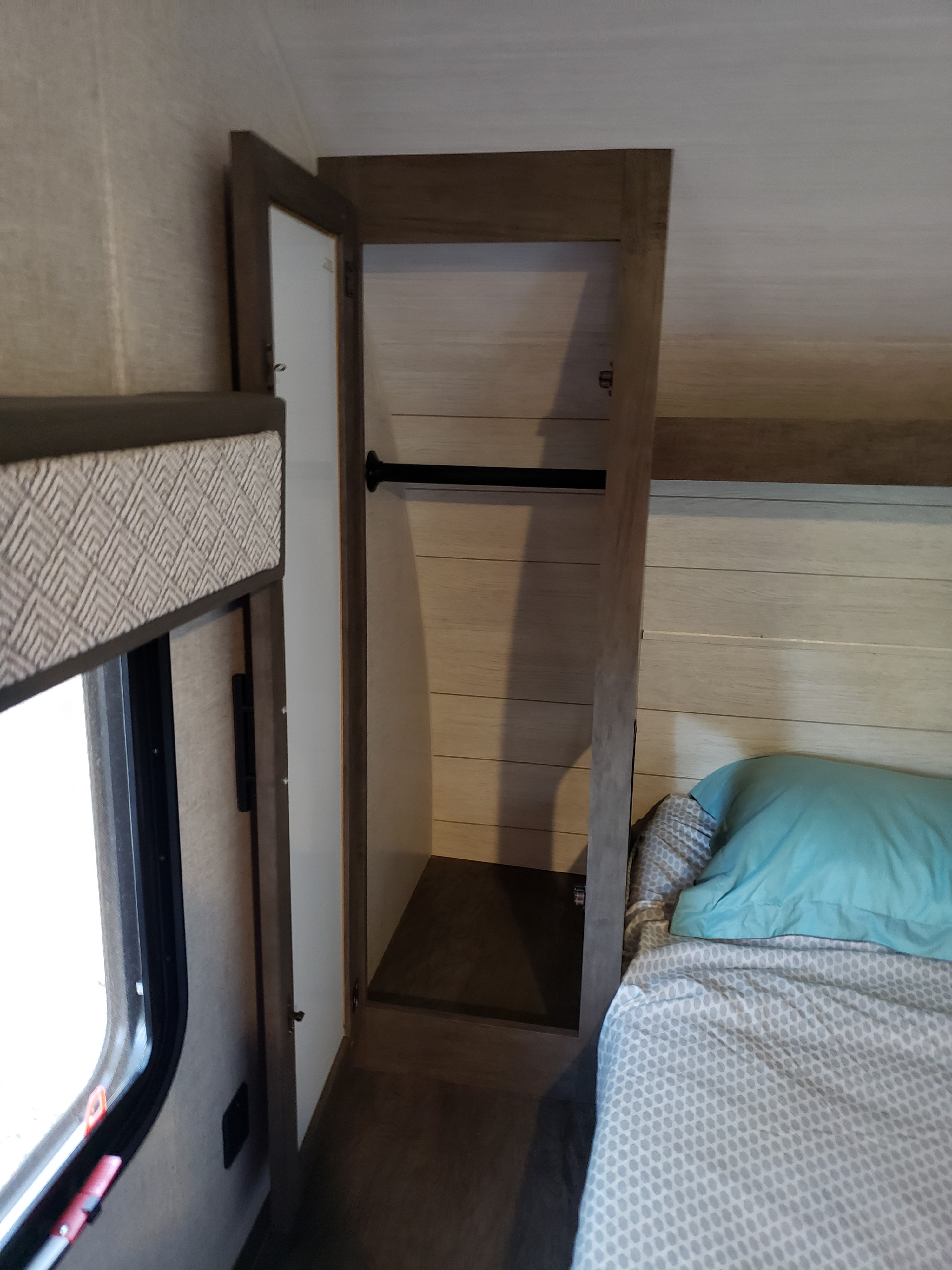 RV rental interior: View of the compact bedroom with an open closet and hanging rod, plus a bed and window.. Forest River Salem Cruise Lite 2020