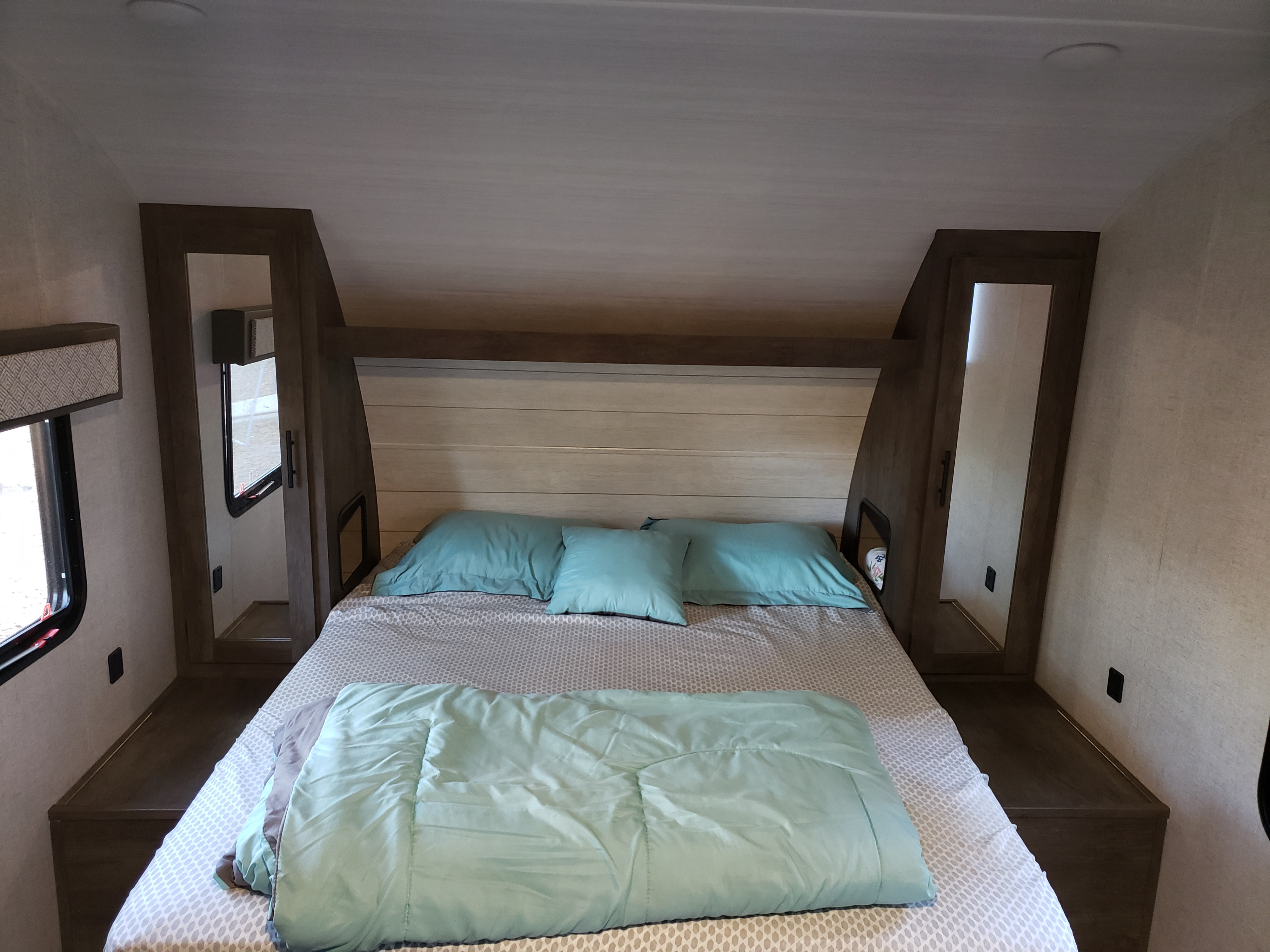 Experience comfort in this RV rental bedroom featuring a full bed, built-in storage, and side windows.. Forest River Salem Cruise Lite 2020