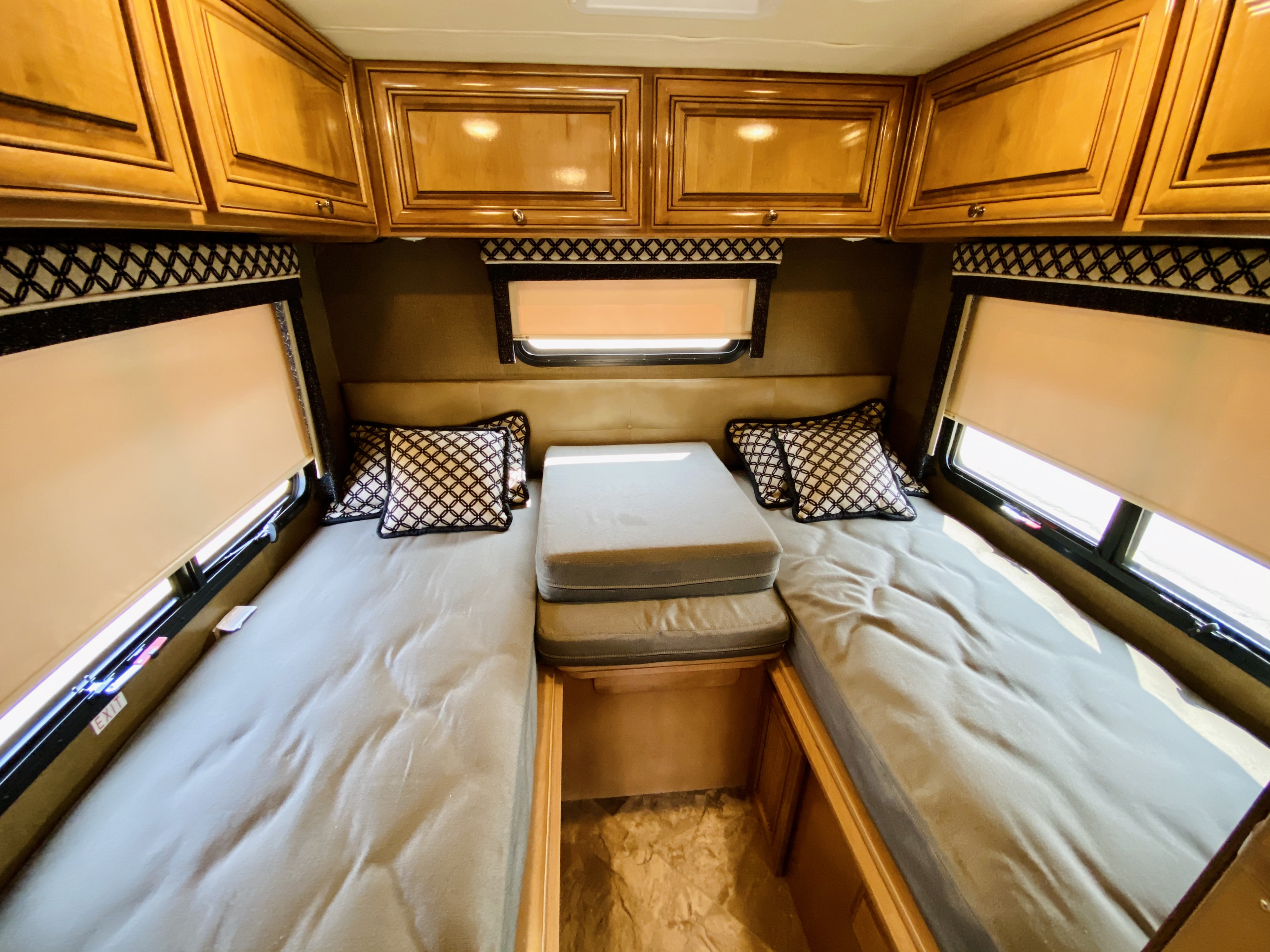 Cozy RV rental sleeping area featuring twin beds, overhead storage, and window views.. Thor Motor Coach Siesta 2017