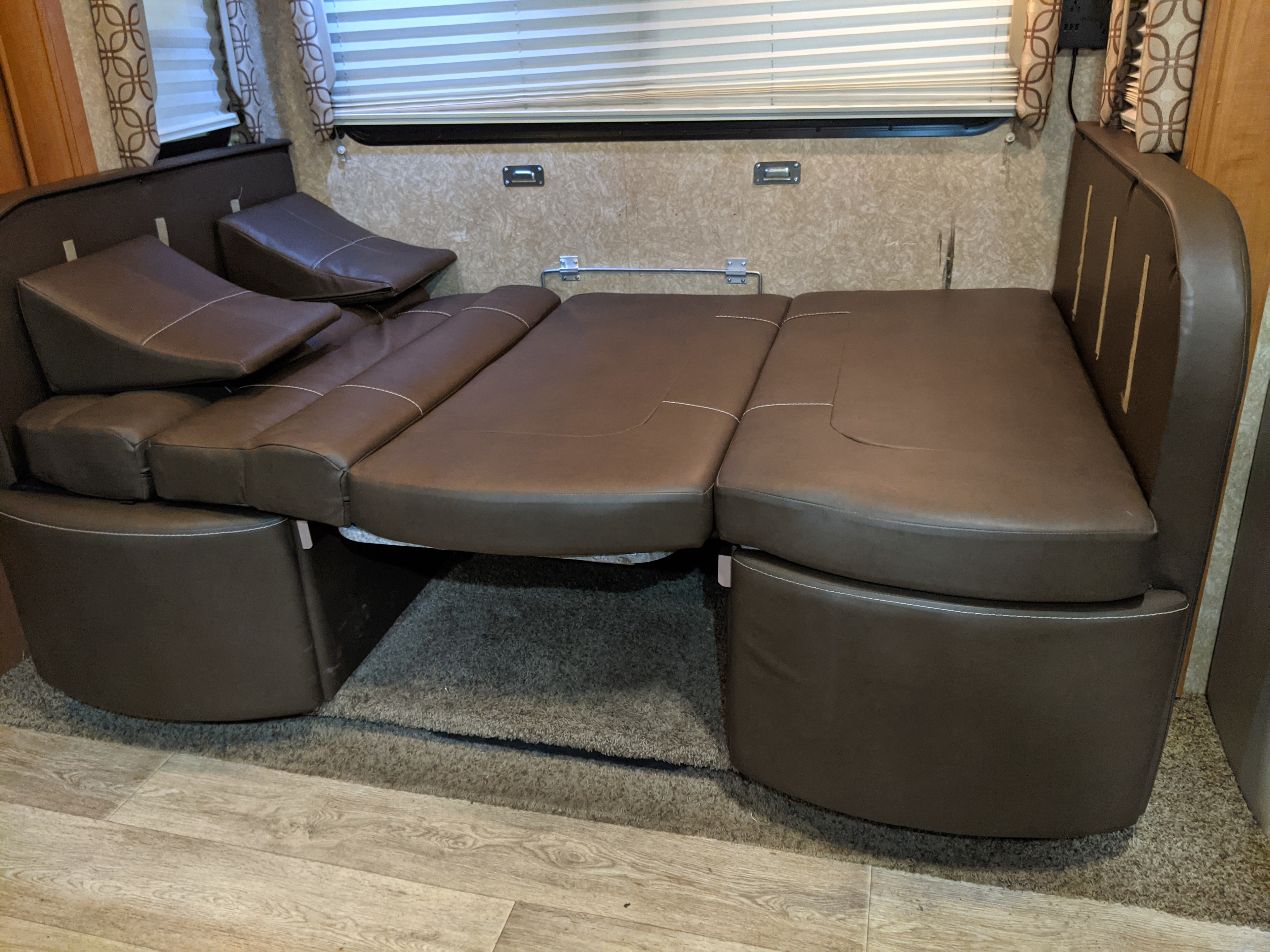 RV rental: Brown leather sofa converts to a bed, offering versatile seating and comfortable sleeping in this RV interior.. Thor Motor Coach Four Winds Siesta Sprinter 2011