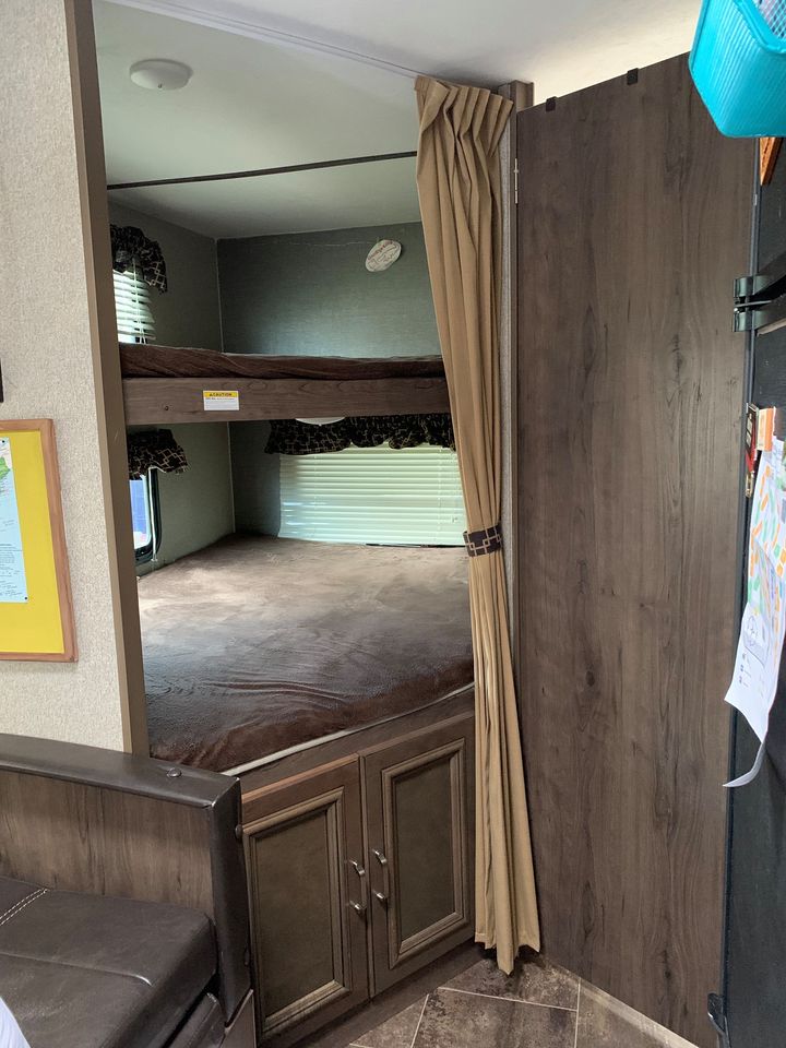 Inside an RV rental: view of comfortable bunk beds, lower bed with storage cabinets. Perfect for families on a road trip.. Other Passport 2019