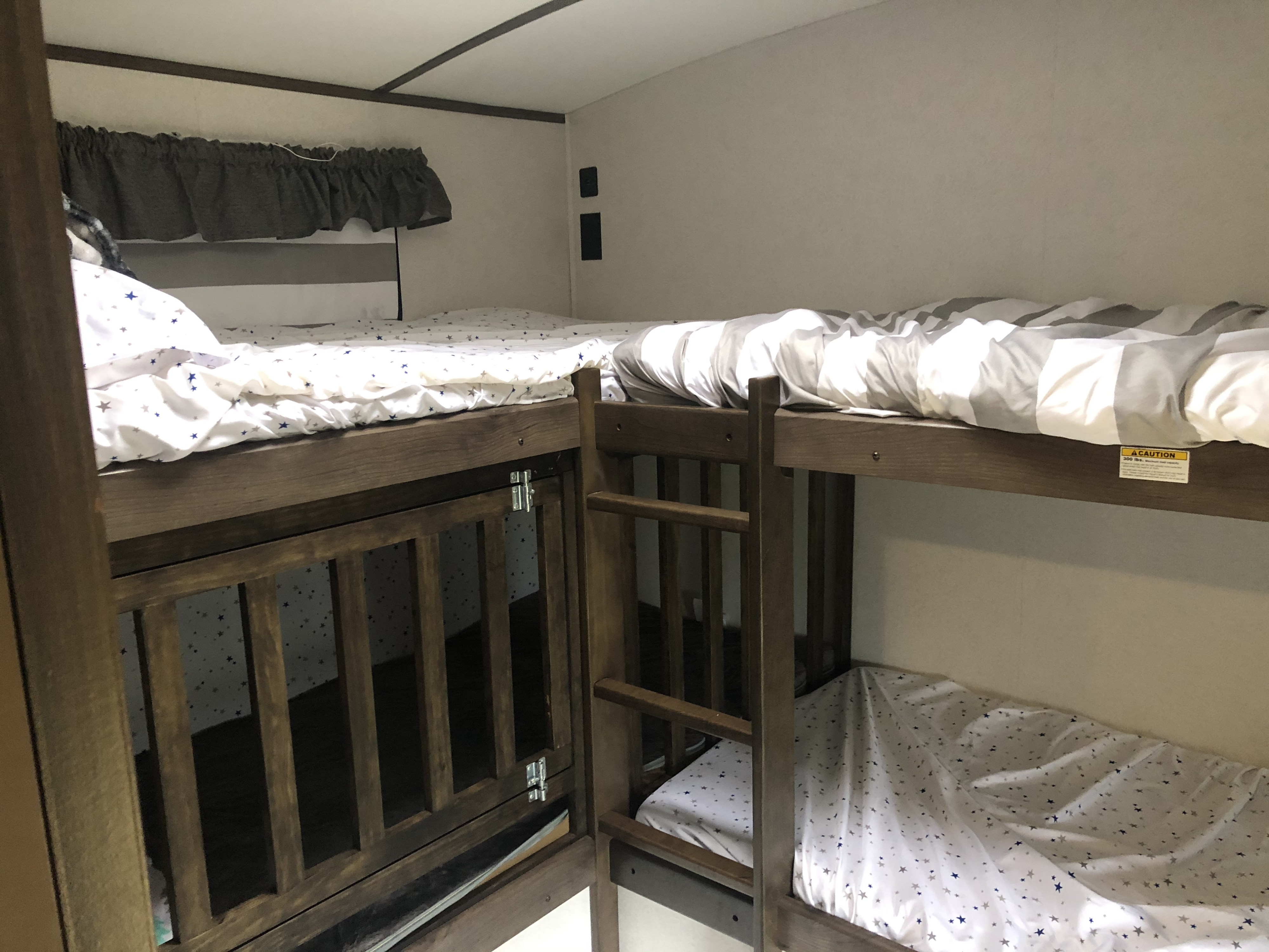 Family-friendly RV rental with cozy bunk beds, featuring a ladder & patterned bedding for comfortable sleeping.. Keystone Passport 2020